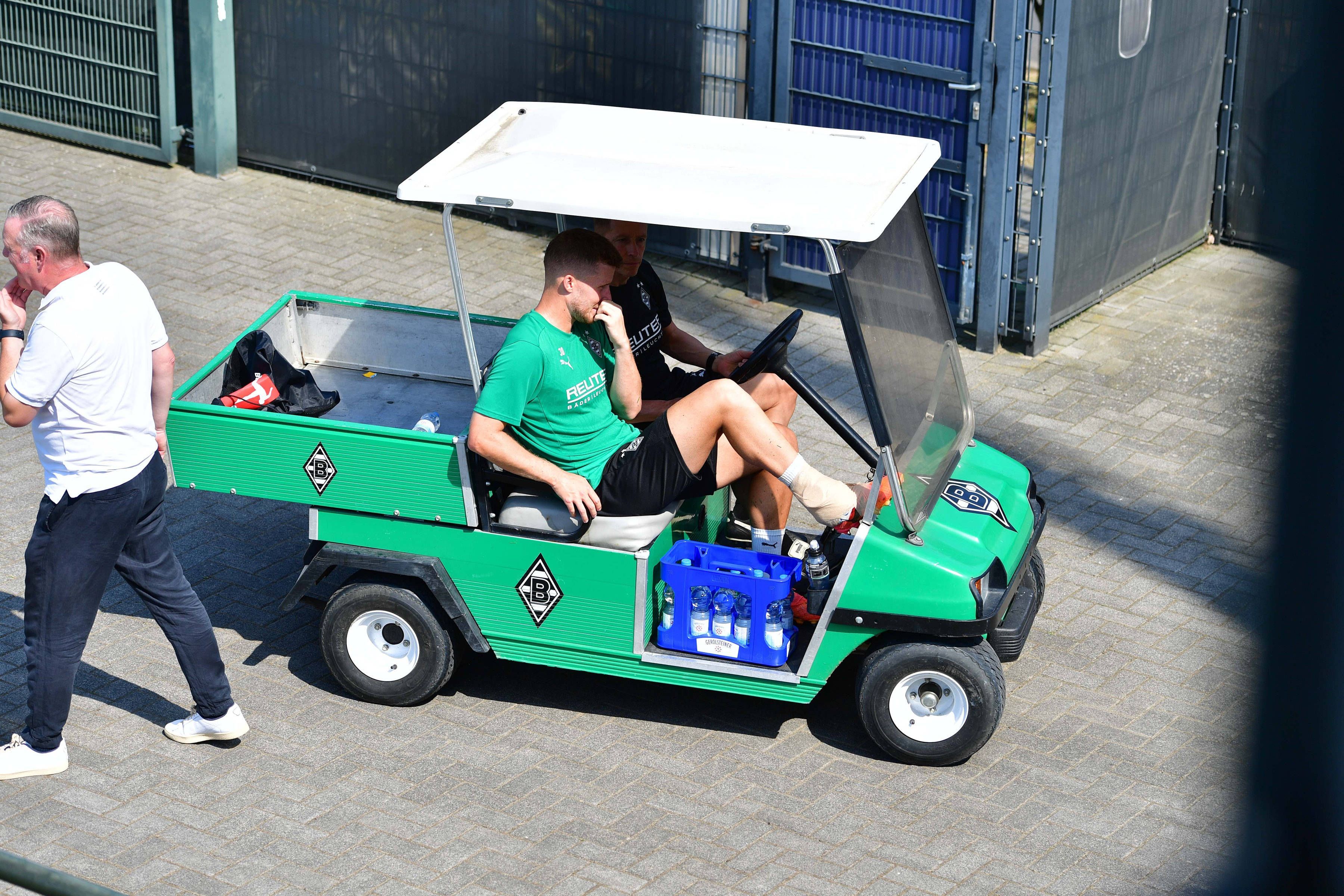 Borussia Mönchengladbachs Nico Elvedi wird mit einem Golfcart vom Trainingsplatz gebracht. Sein rechter Knöchel ist bandagiert.