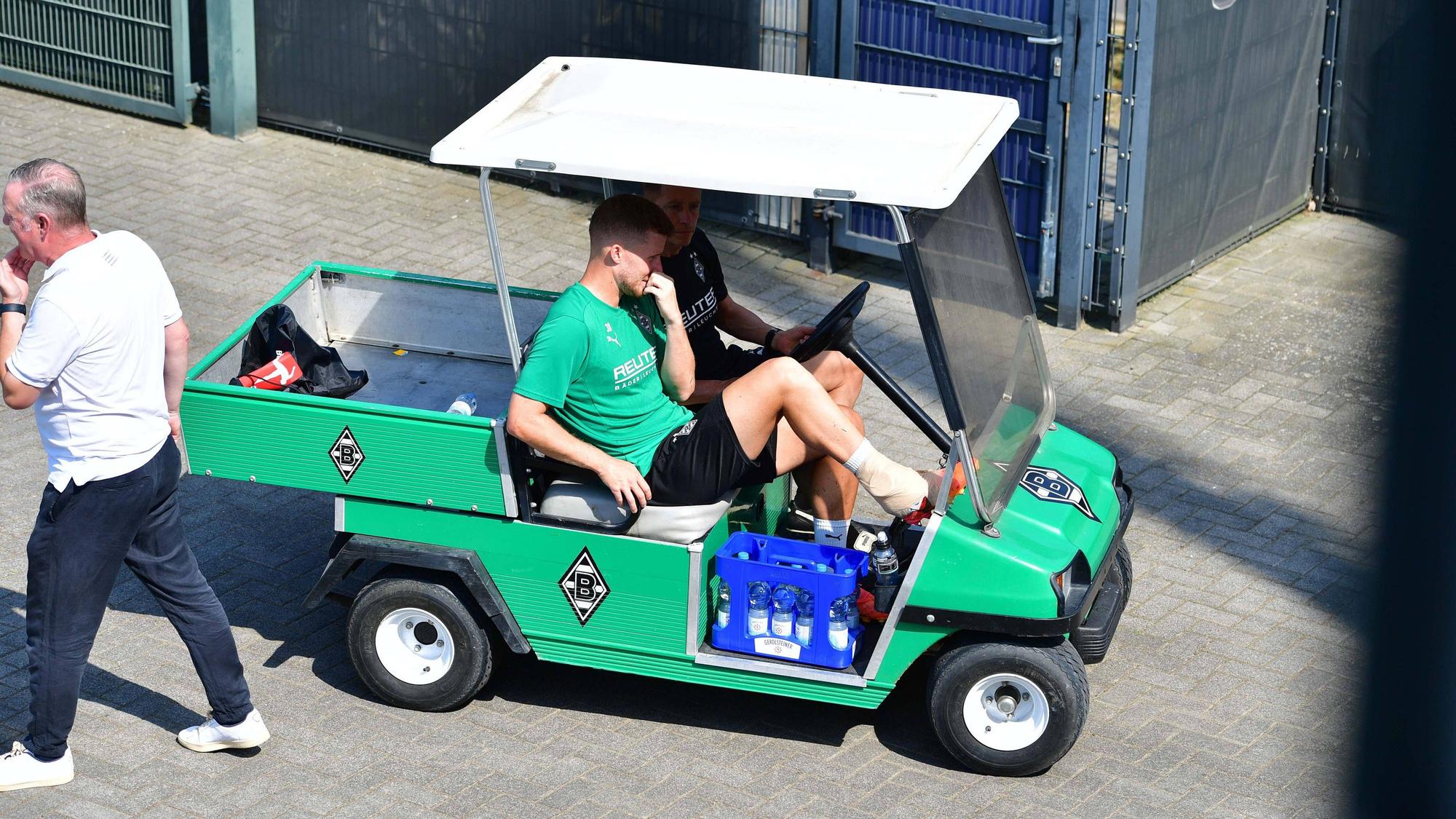 Borussia Mönchengladbachs Nico Elvedi wird mit einem Golfcart vom Trainingsplatz gebracht. Sein rechter Knöchel ist bandagiert.