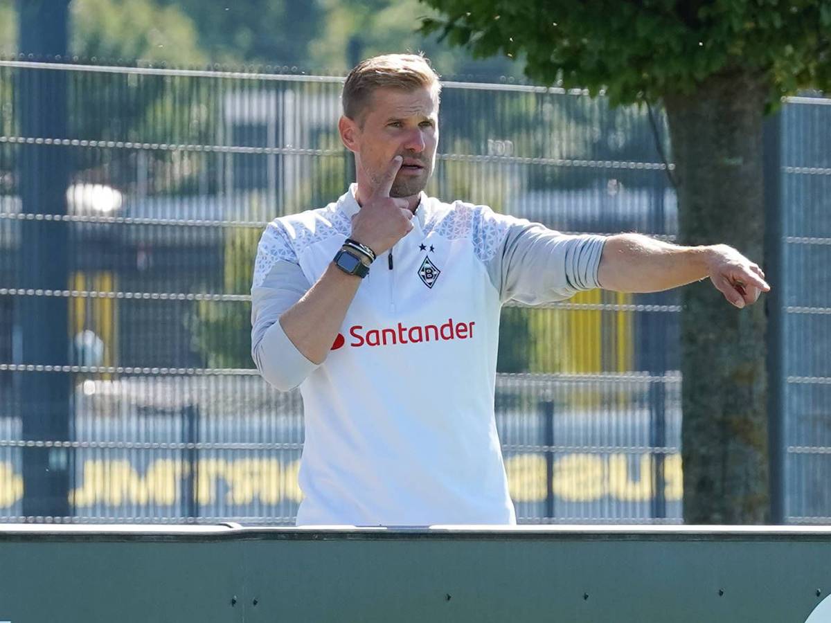 Oliver Kirch hebt den rechten Arm und zeigt etwas an.