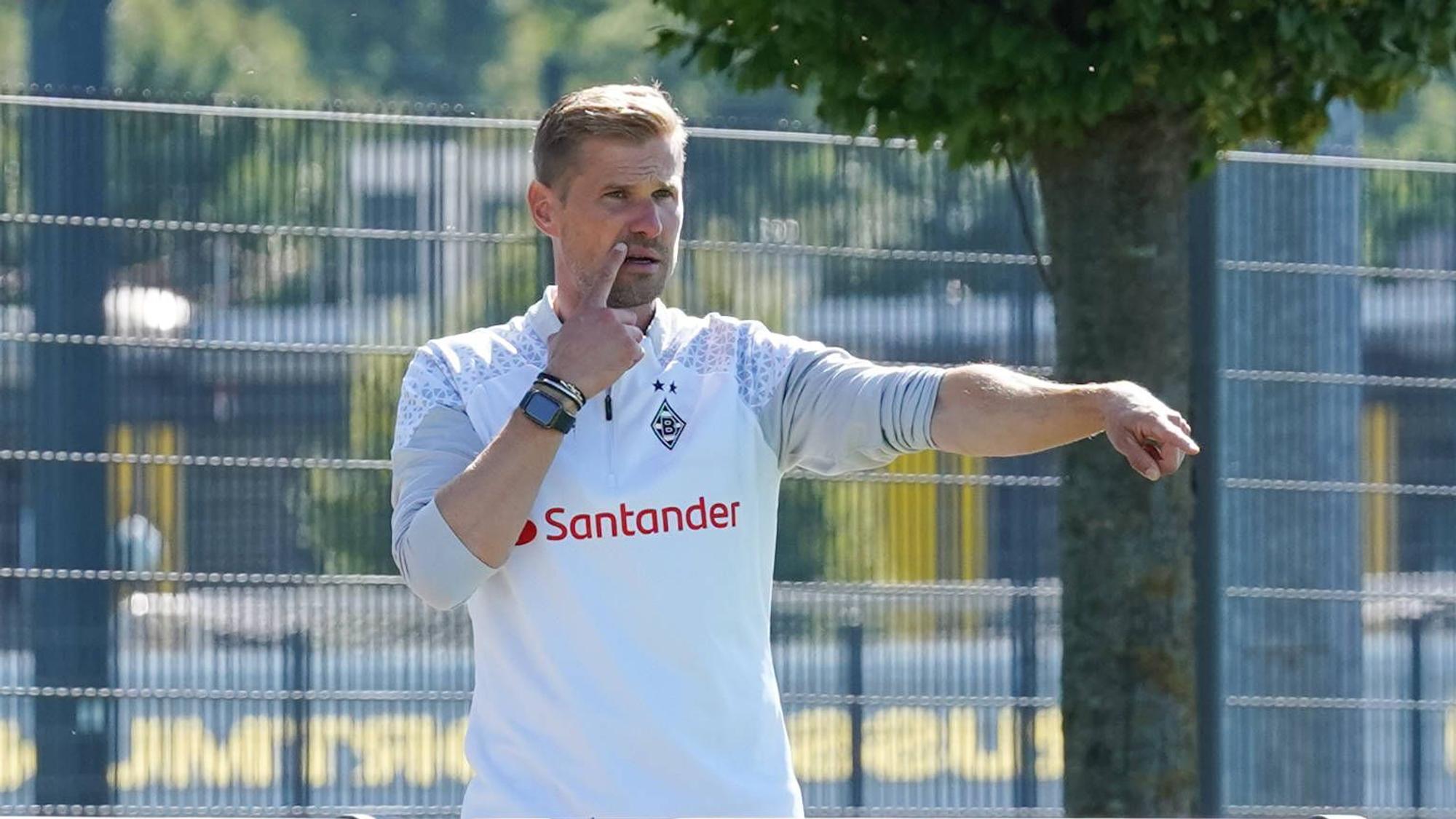 Oliver Kirch hebt den rechten Arm und zeigt etwas an.