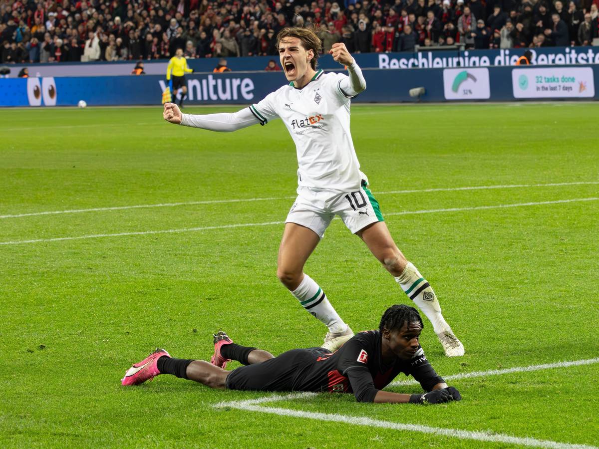 Florian Neuhaus bejubelt eine Grätsche gegen Jeremie Frimpong, der am Boden liegt.