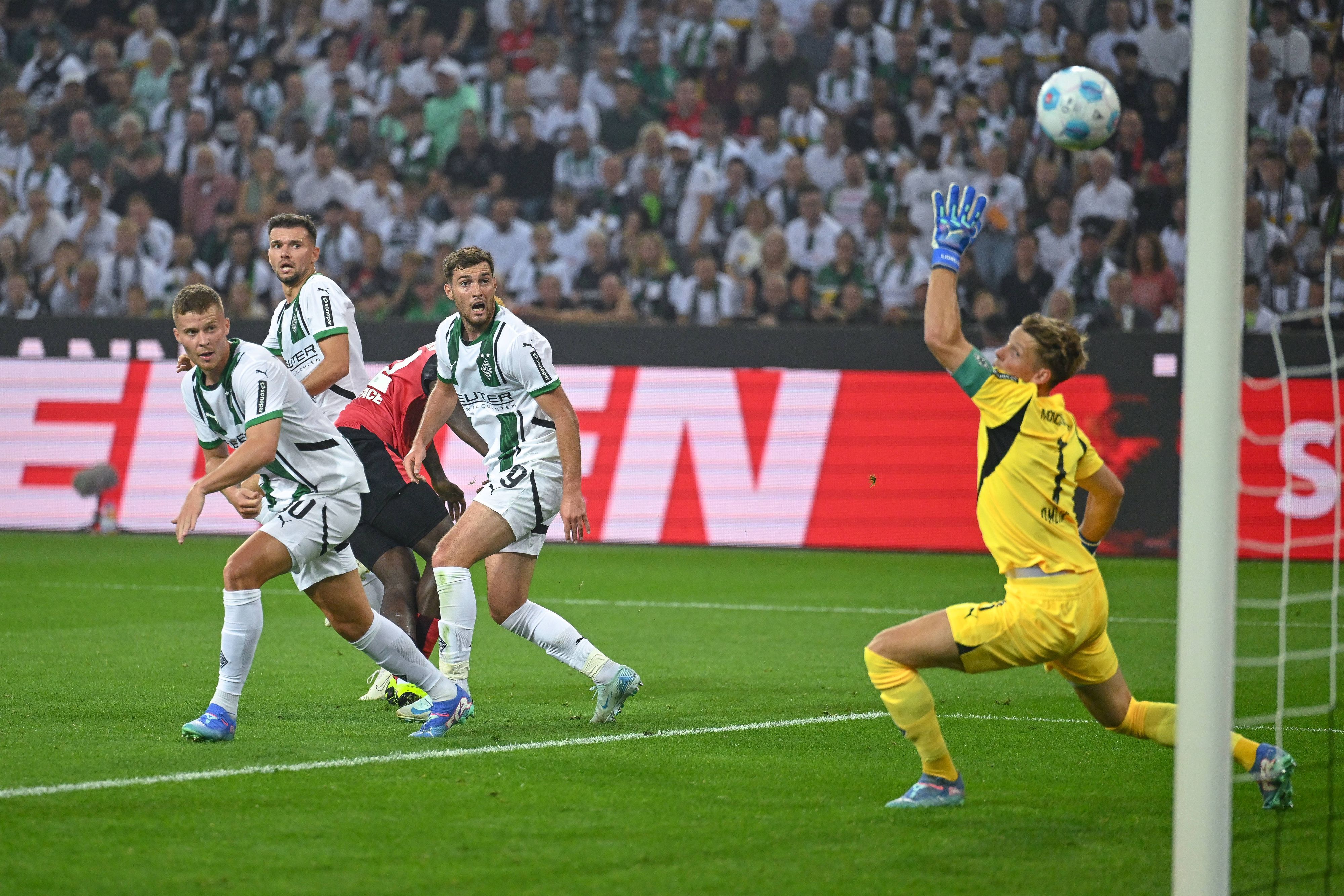 Leverkusens Victor Boniface schießt, die Gladbacher Nico Elvedi, Kevin Stöger und Joe Scally schauen dem Ball bhinterher.