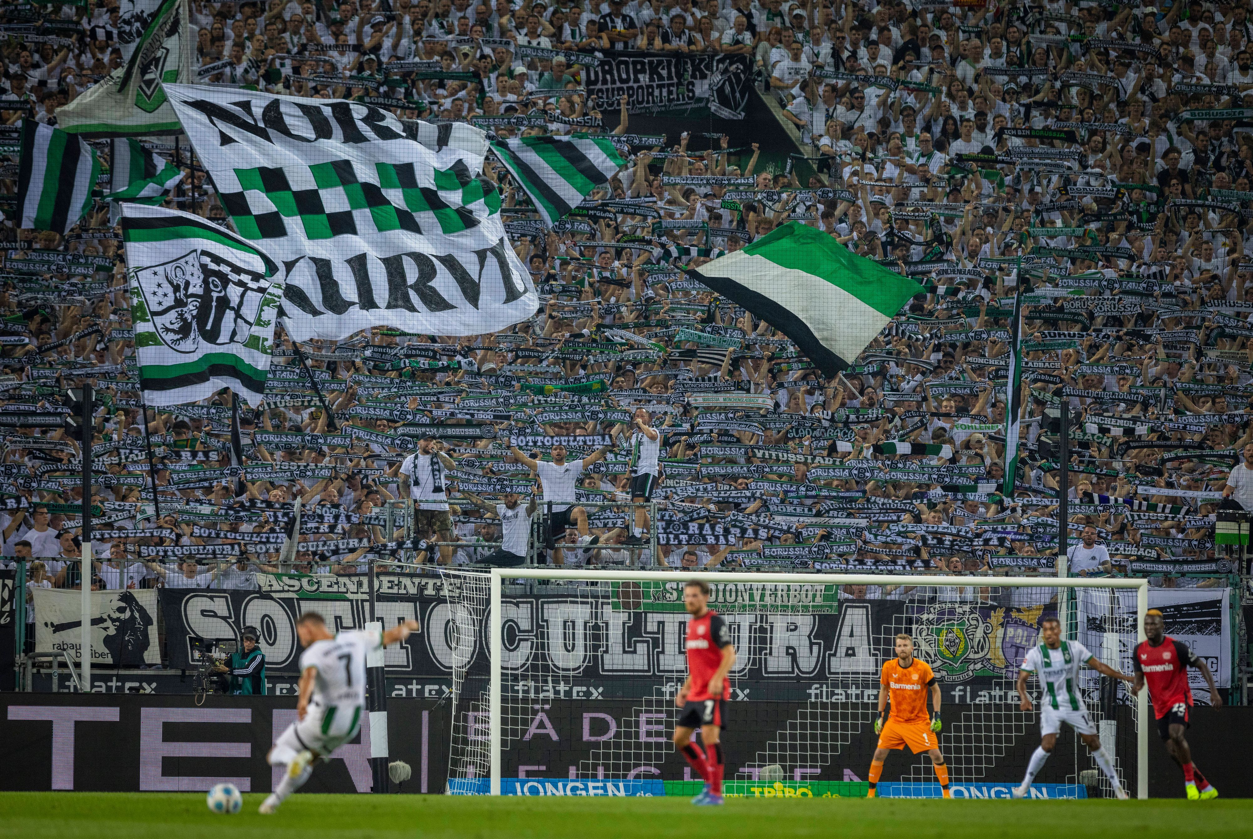 Die Fans von Borussia Mönchengladbach strecken den Schal in die Höhe.