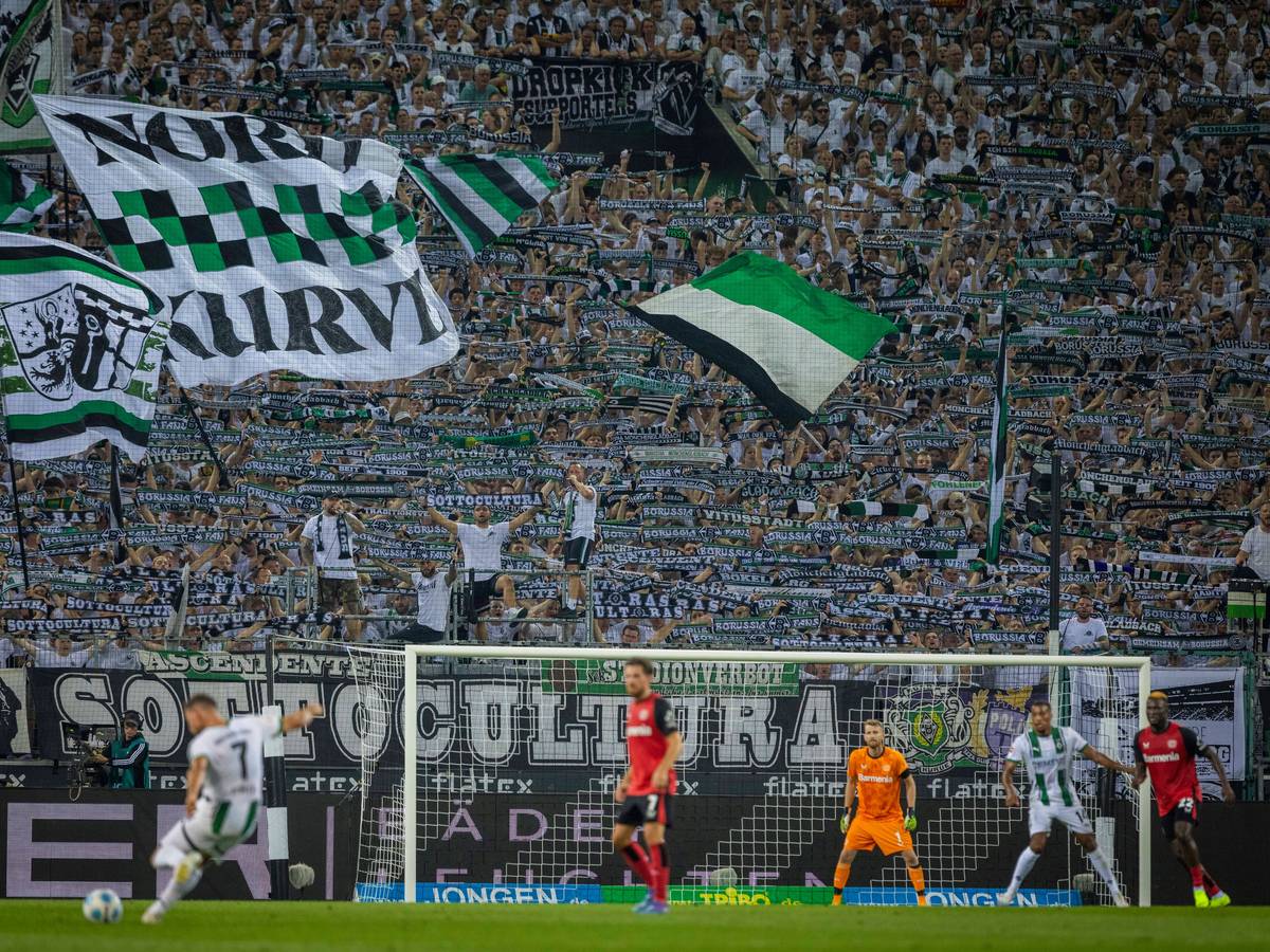 Die Fans von Borussia Mönchengladbach strecken den Schal in die Höhe.