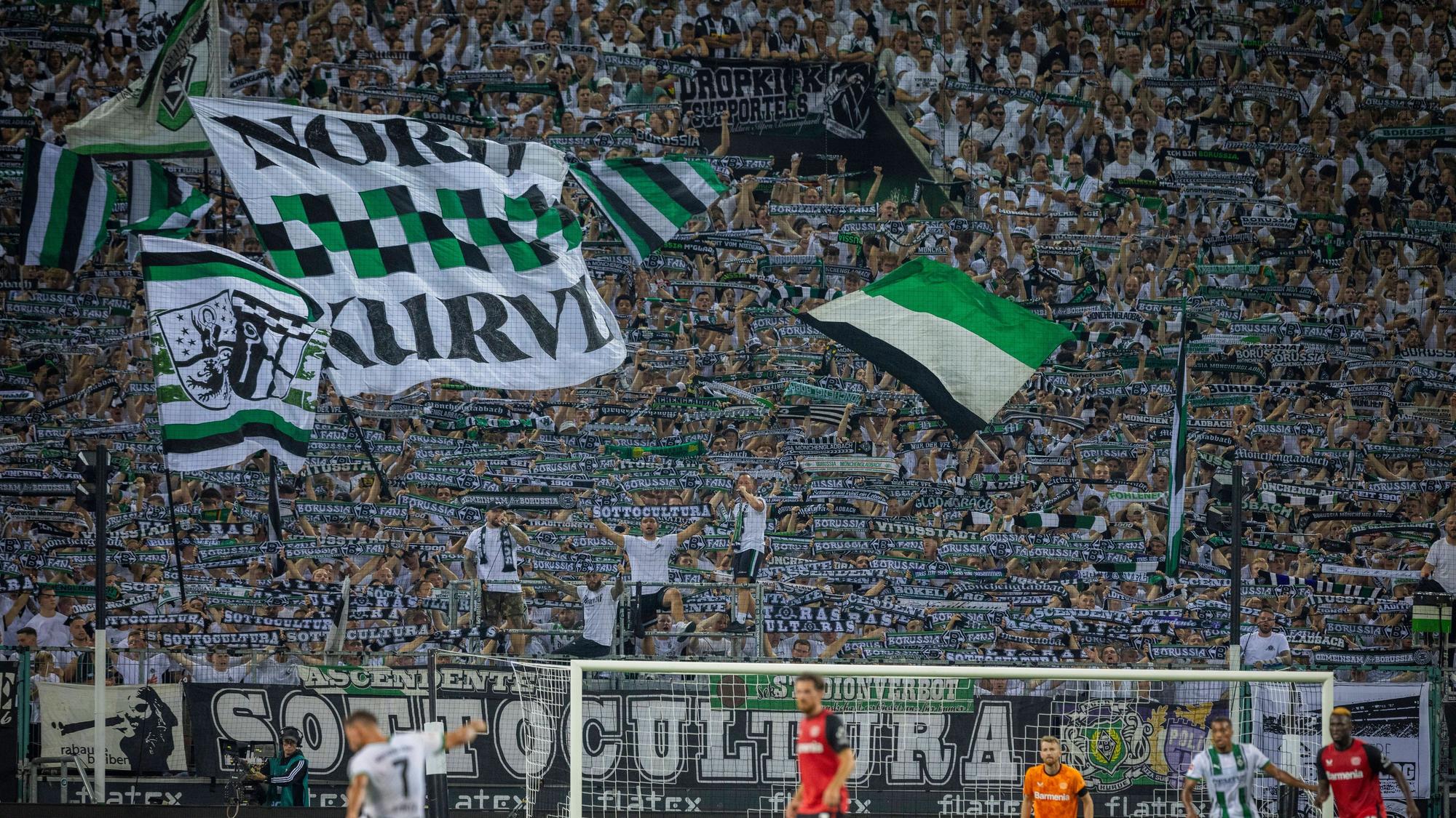 Die Fans von Borussia Mönchengladbach strecken den Schal in die Höhe.