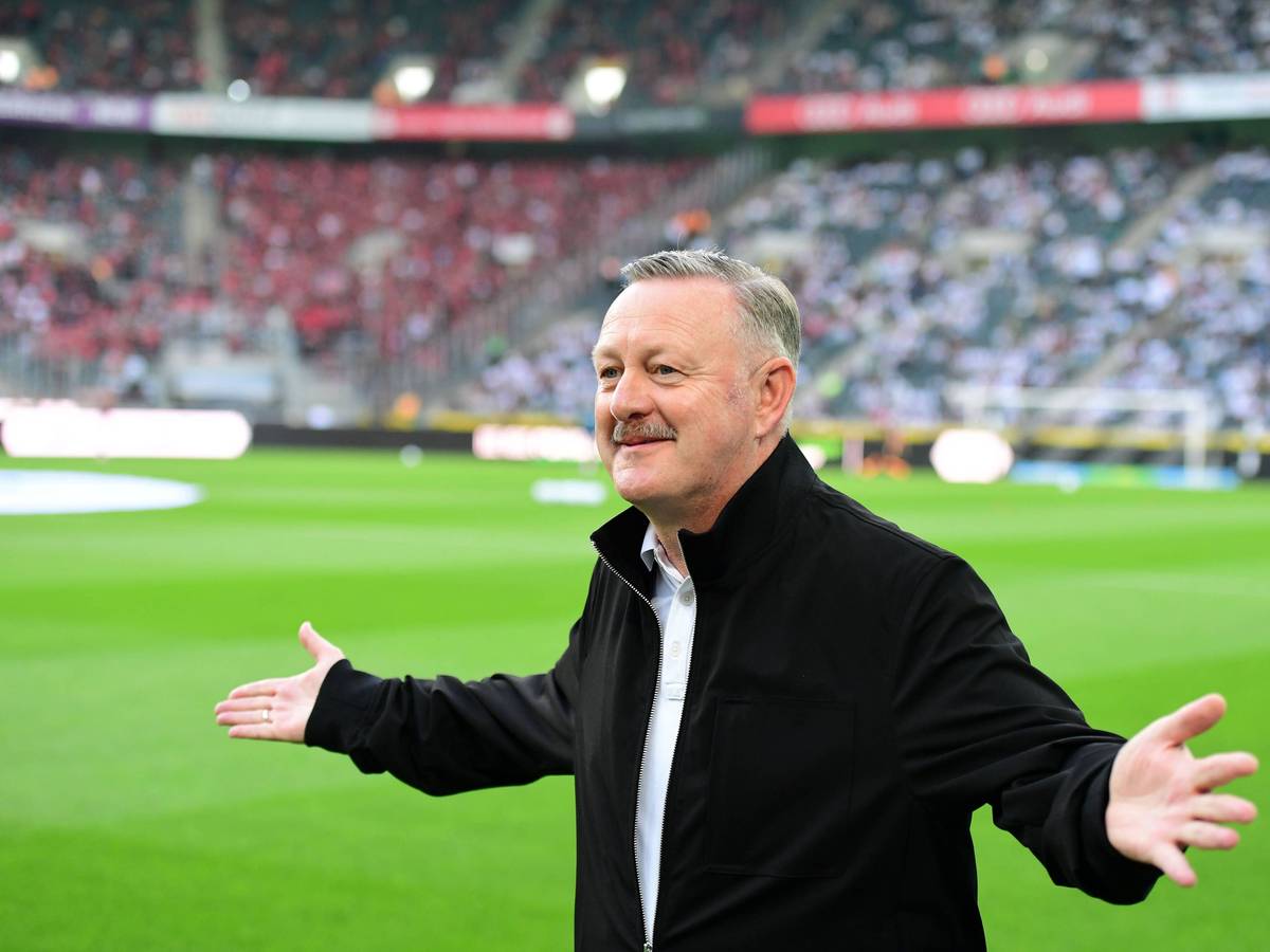 Roland Virkus streckt seine Arme aus und lächelt.