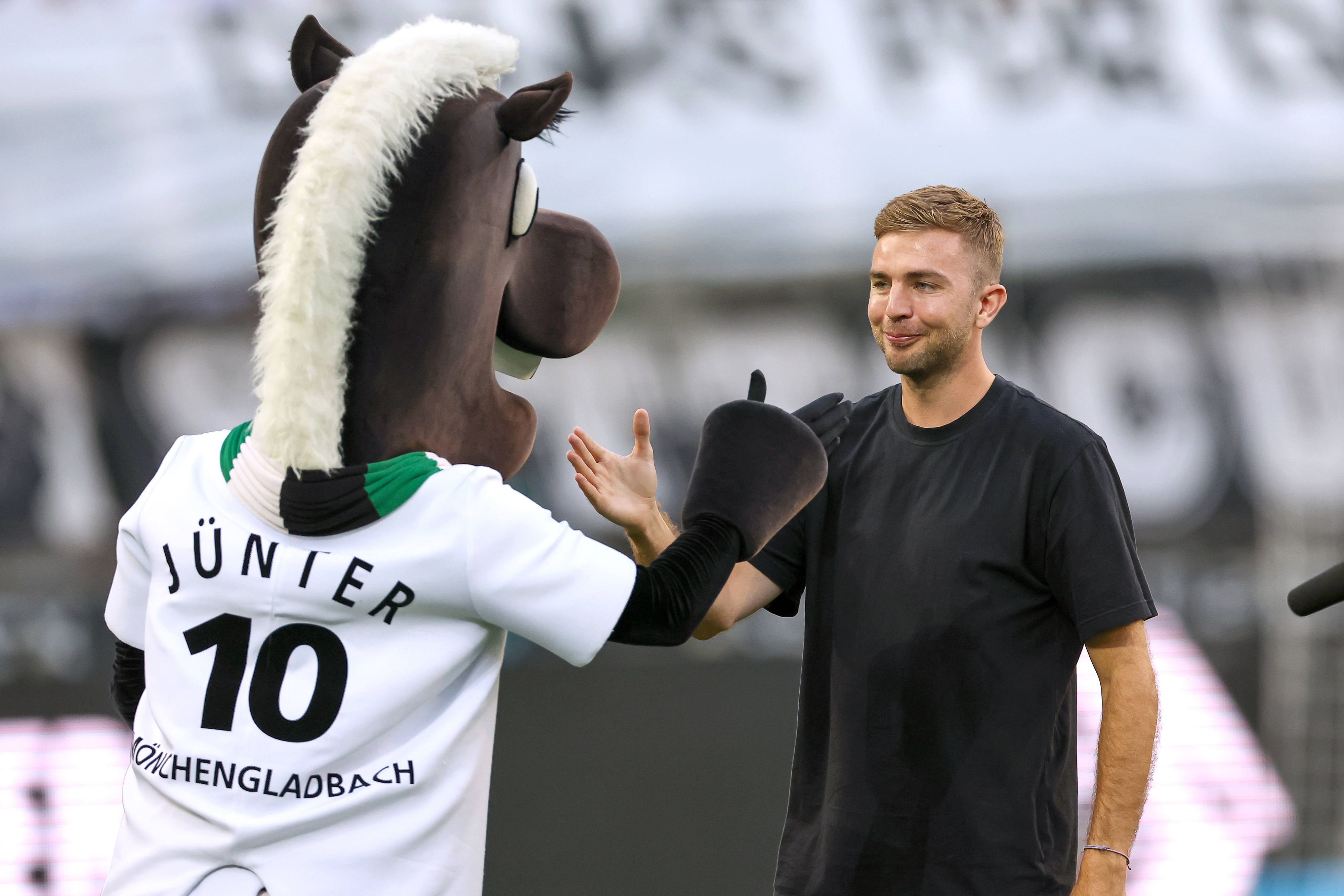 Christoph Kramer schlägt mit dem Maskottchen von Borussia Mönchengladbach ein.
