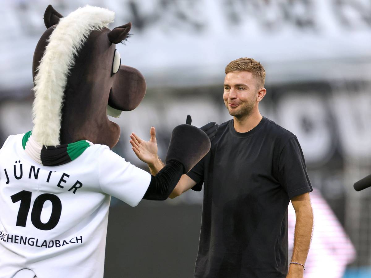 Christoph Kramer schlägt mit dem Maskottchen von Borussia Mönchengladbach ein.