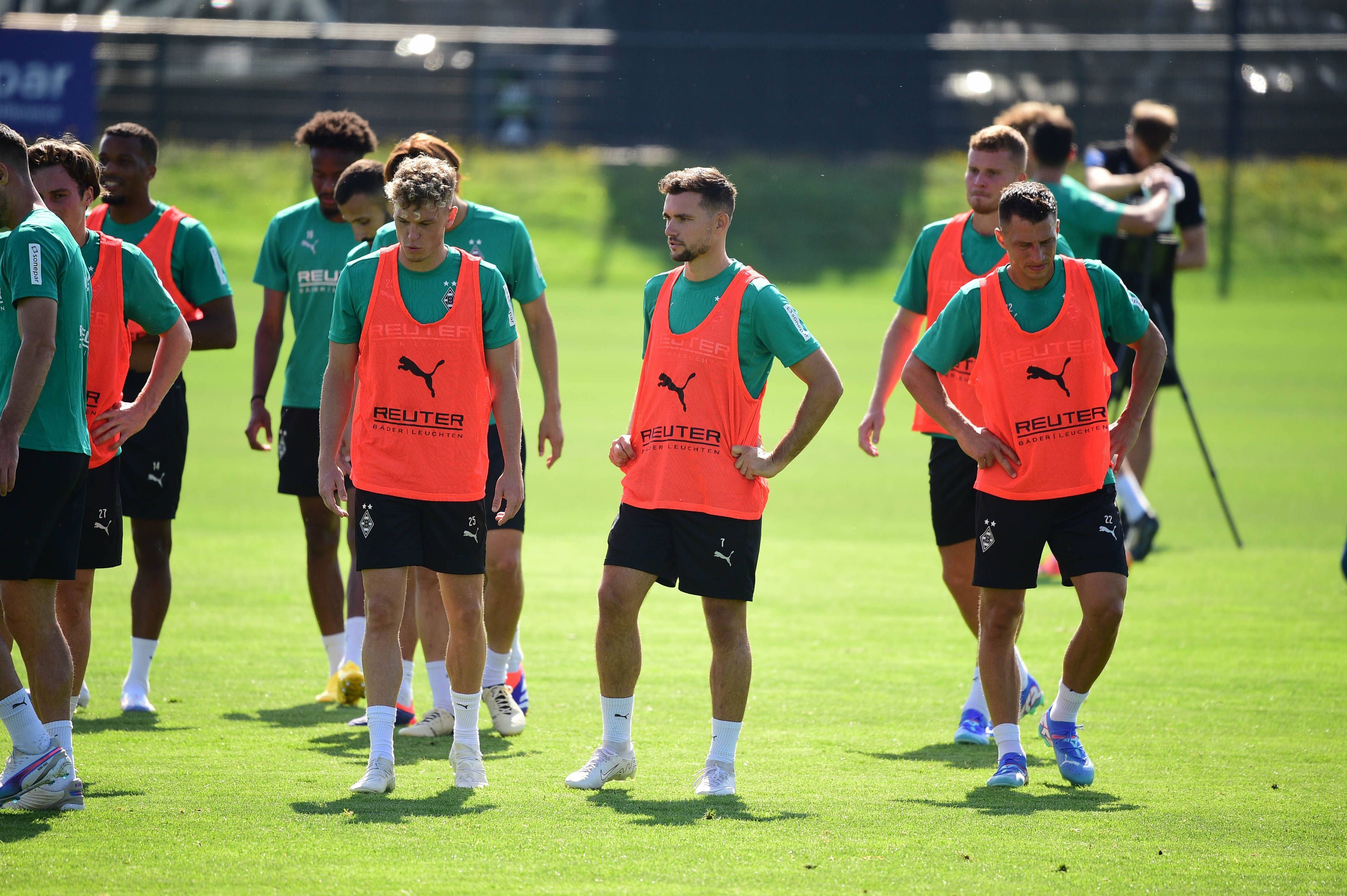 Die Gladbach-Profis Robin Hack, Kevin Stöger und Stefan Lainer stehen nebeneinander auf dem Trainingsplatz und schnaufen durch.