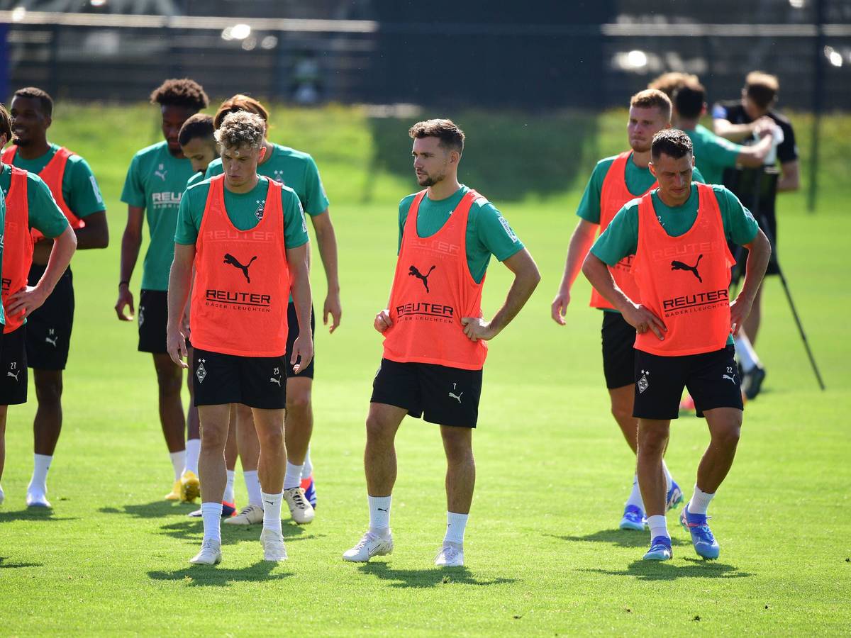 Die Gladbach-Profis Robin Hack, Kevin Stöger und Stefan Lainer stehen nebeneinander auf dem Trainingsplatz und schnaufen durch.