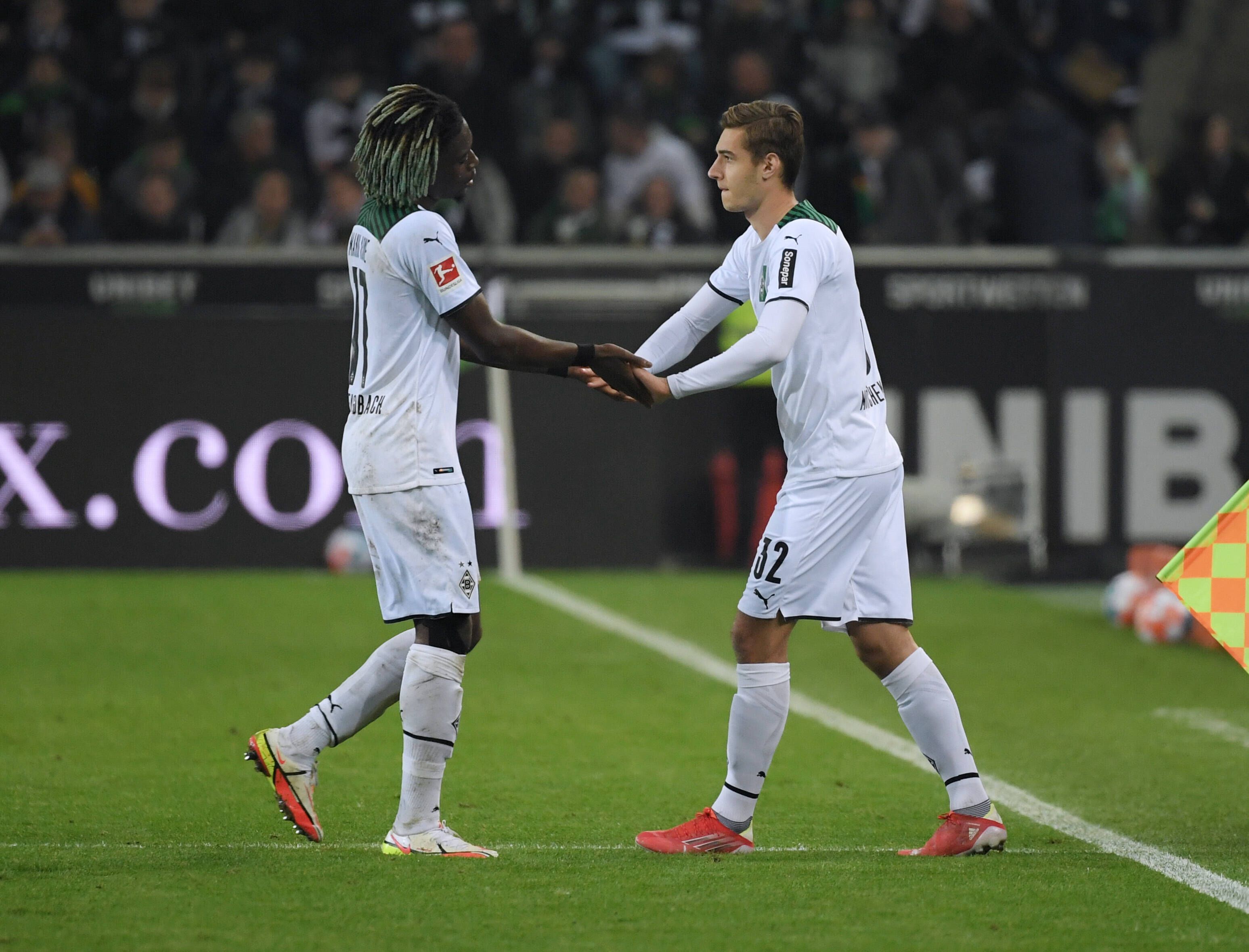 Manu Koné und Florian Neuhaus bei einem Wechsel am Seitenrand.