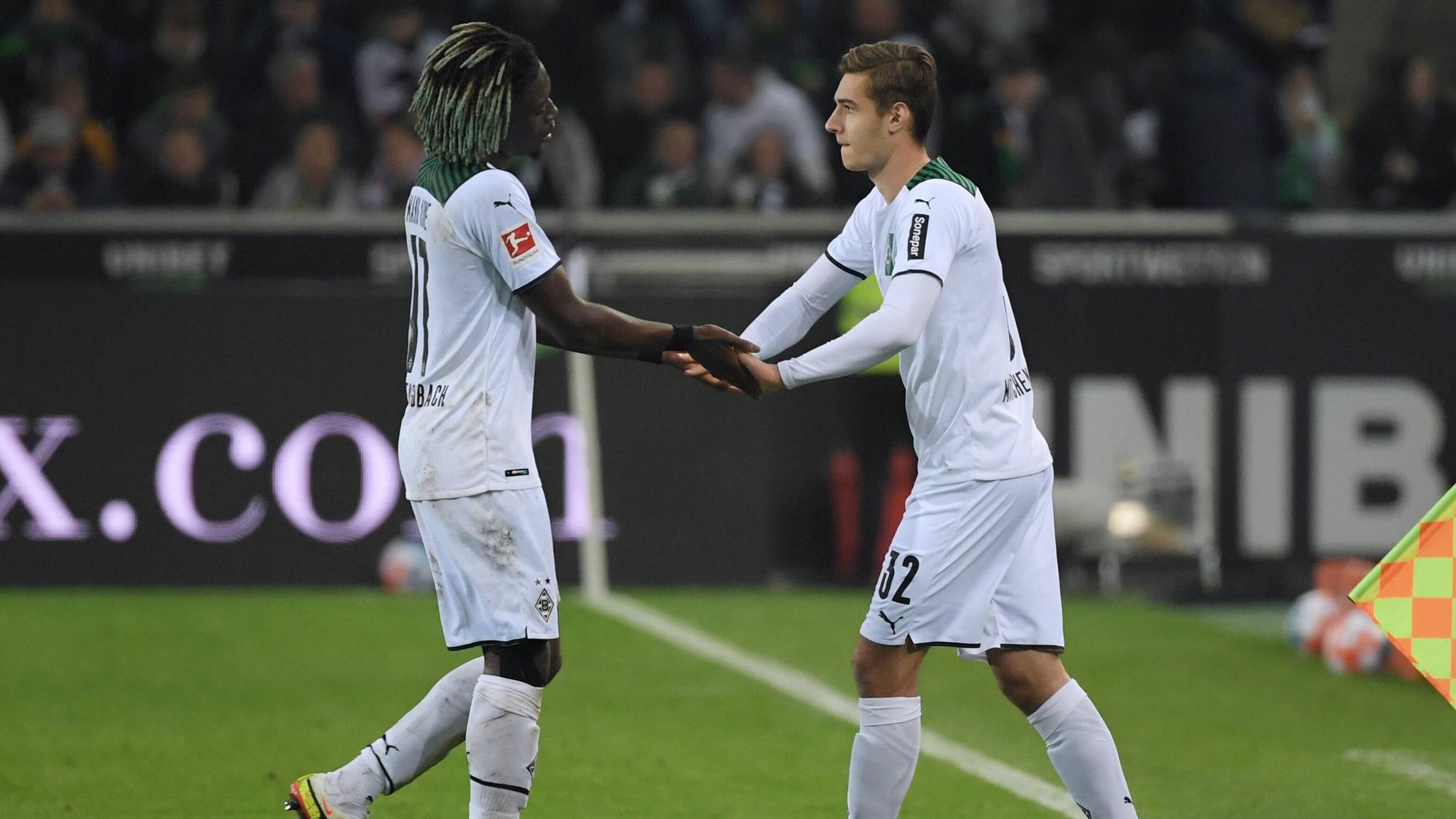 Manu Koné und Florian Neuhaus bei einem Wechsel am Seitenrand.
