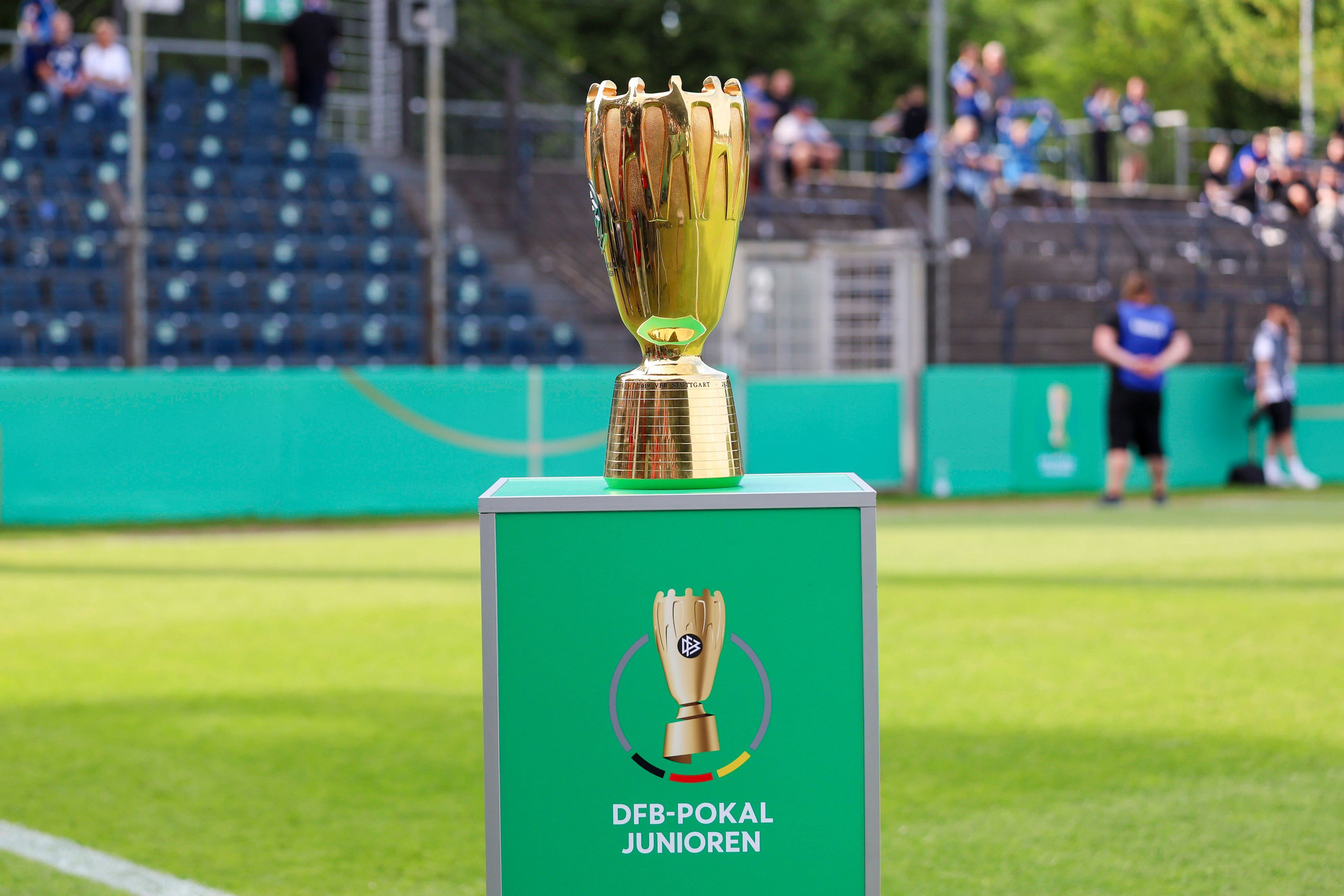 Der goldene DFB-Pokal der Junioren auf einem grünen Sockel.