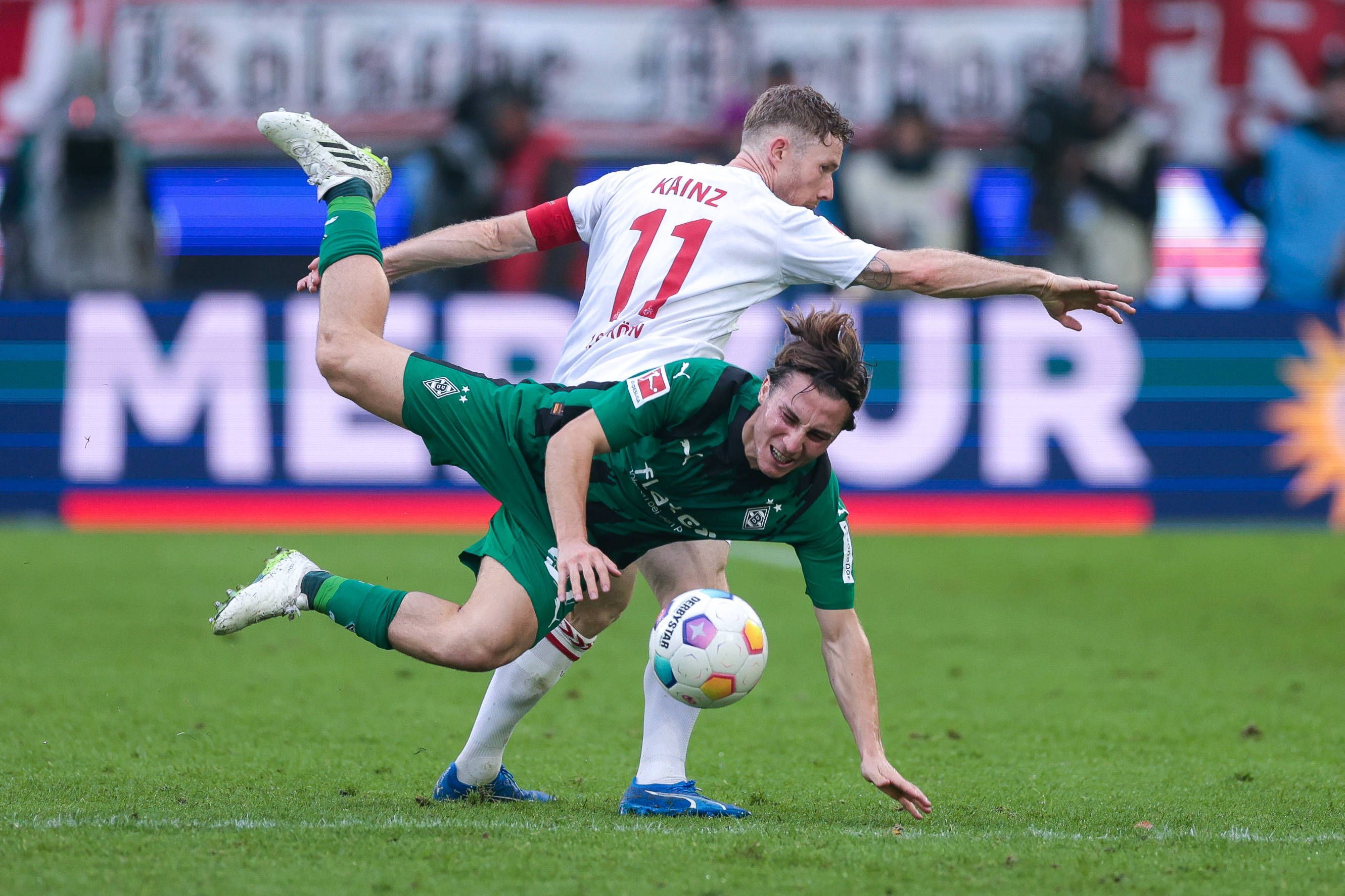 Borussia Mönchengladbachs Rocco Reitz wird von Kölns Florian Kainz im Zweikampf zu Fall gebracht.