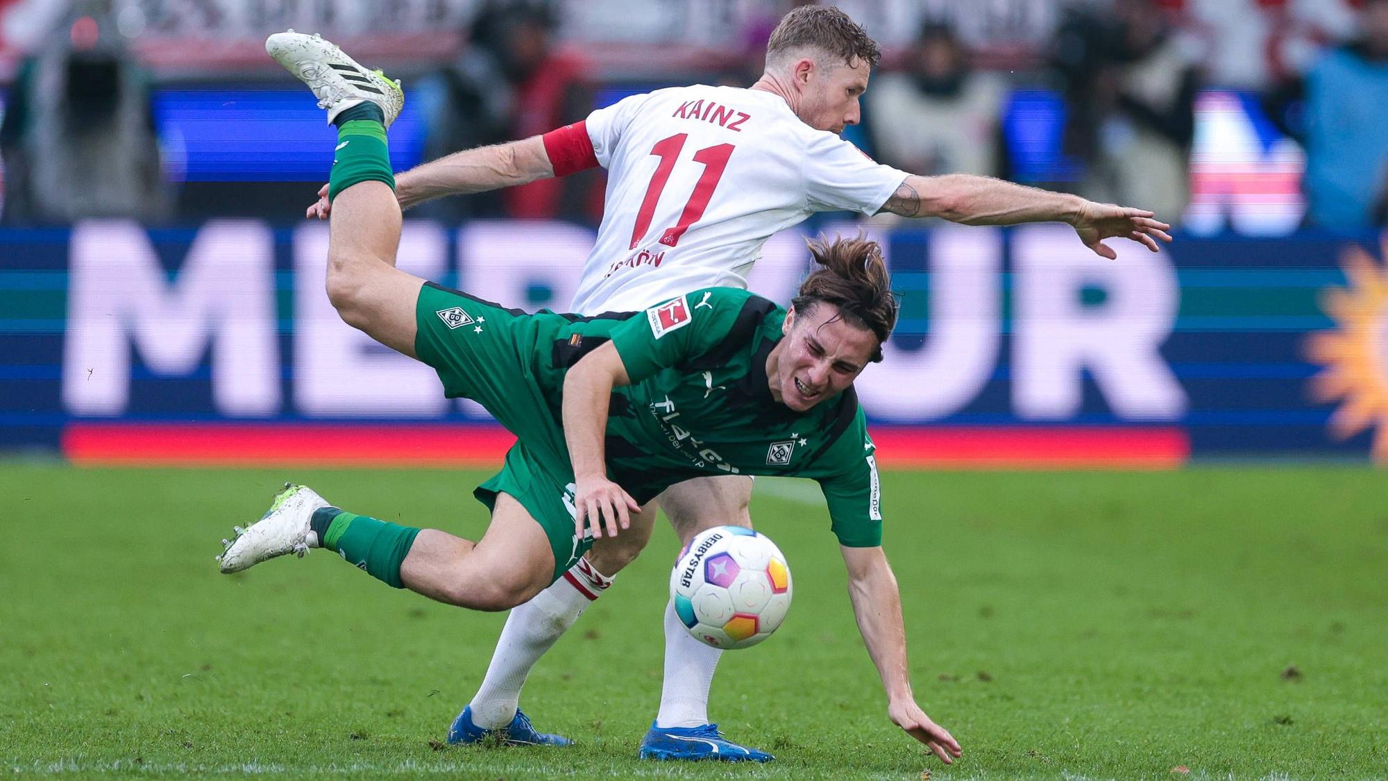 Borussia Mönchengladbachs Rocco Reitz wird von Kölns Florian Kainz im Zweikampf zu Fall gebracht.