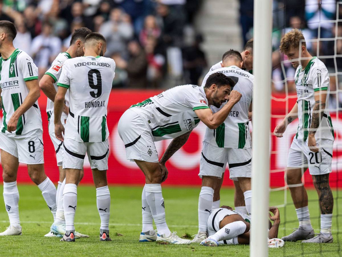 Borussia Mönchengladbachs Alassane Plea liegt im Bundesliga-Spiel gegen den VfB Stuttgart verletzt am Boden, seine Teamkollegen stehen daneben.
