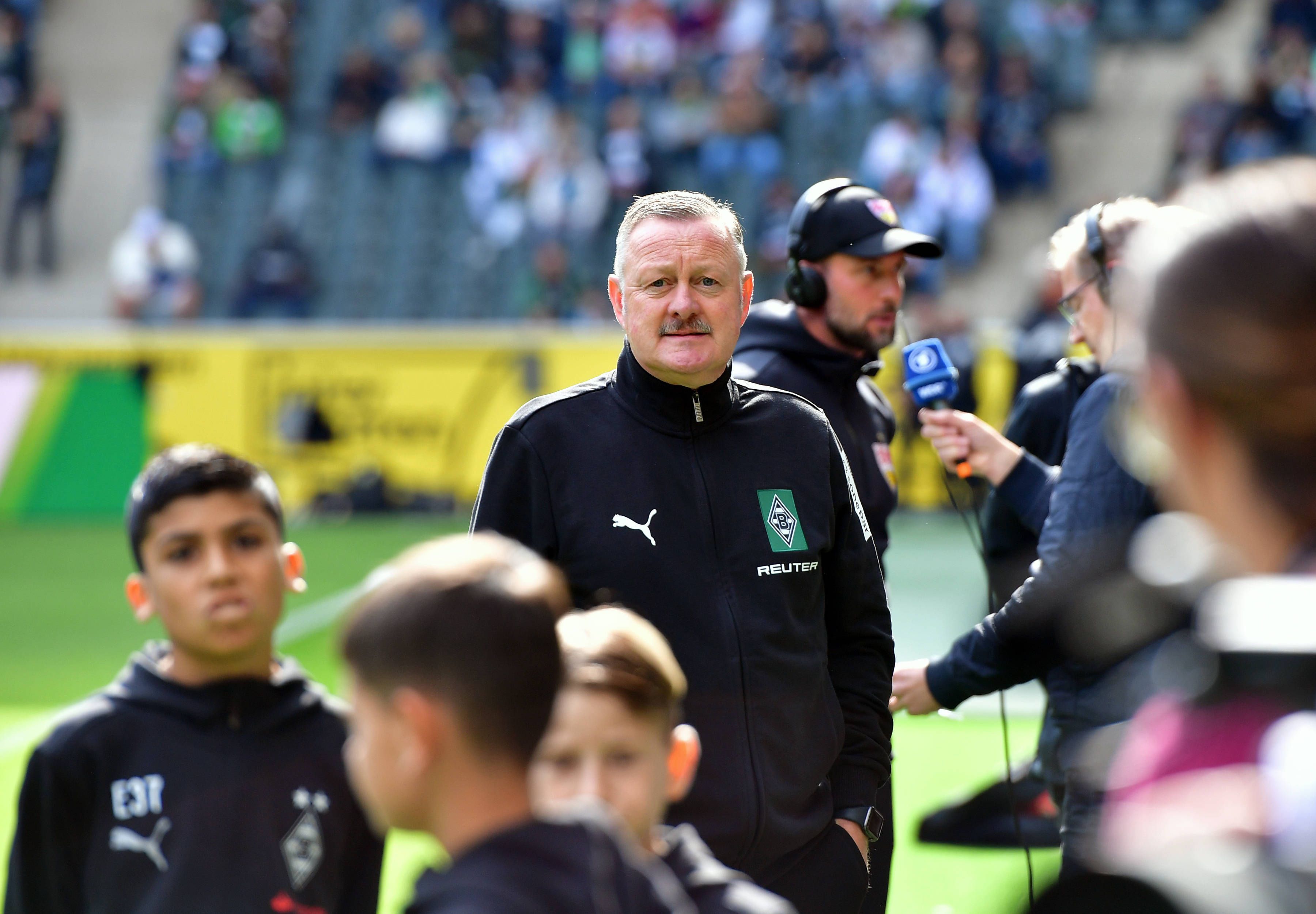 Gladbach-Boss Roland Virkus blickt auf die Tribüne.