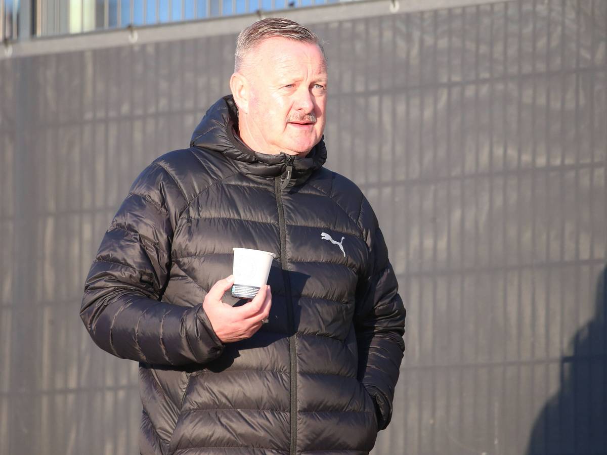 Roland Virkus auf dem Trainingsgelände mit einem Becher Kaffee.