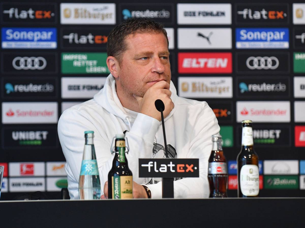 Max Eberl sitzt nachdenklich bei einer Pressekonferenz.