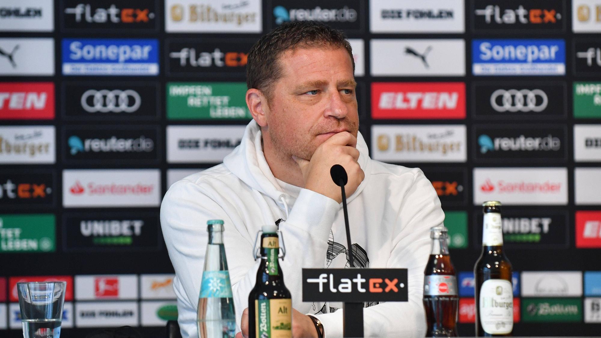 Max Eberl sitzt nachdenklich bei einer Pressekonferenz.