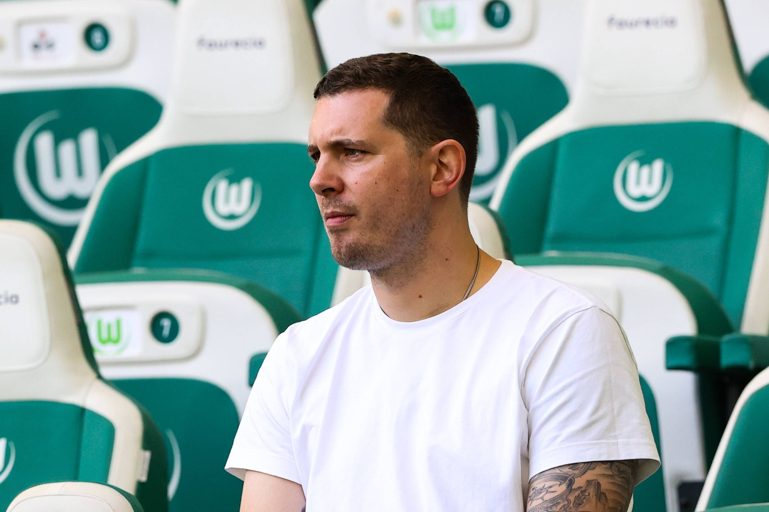 Nils Schmadtke sitzt beim Bundesliga-Spiel des VfL Wolfsburg gegen den FC Bayern München auf der Tribüne und beobachtet das Geschehen auf dem Rasen.