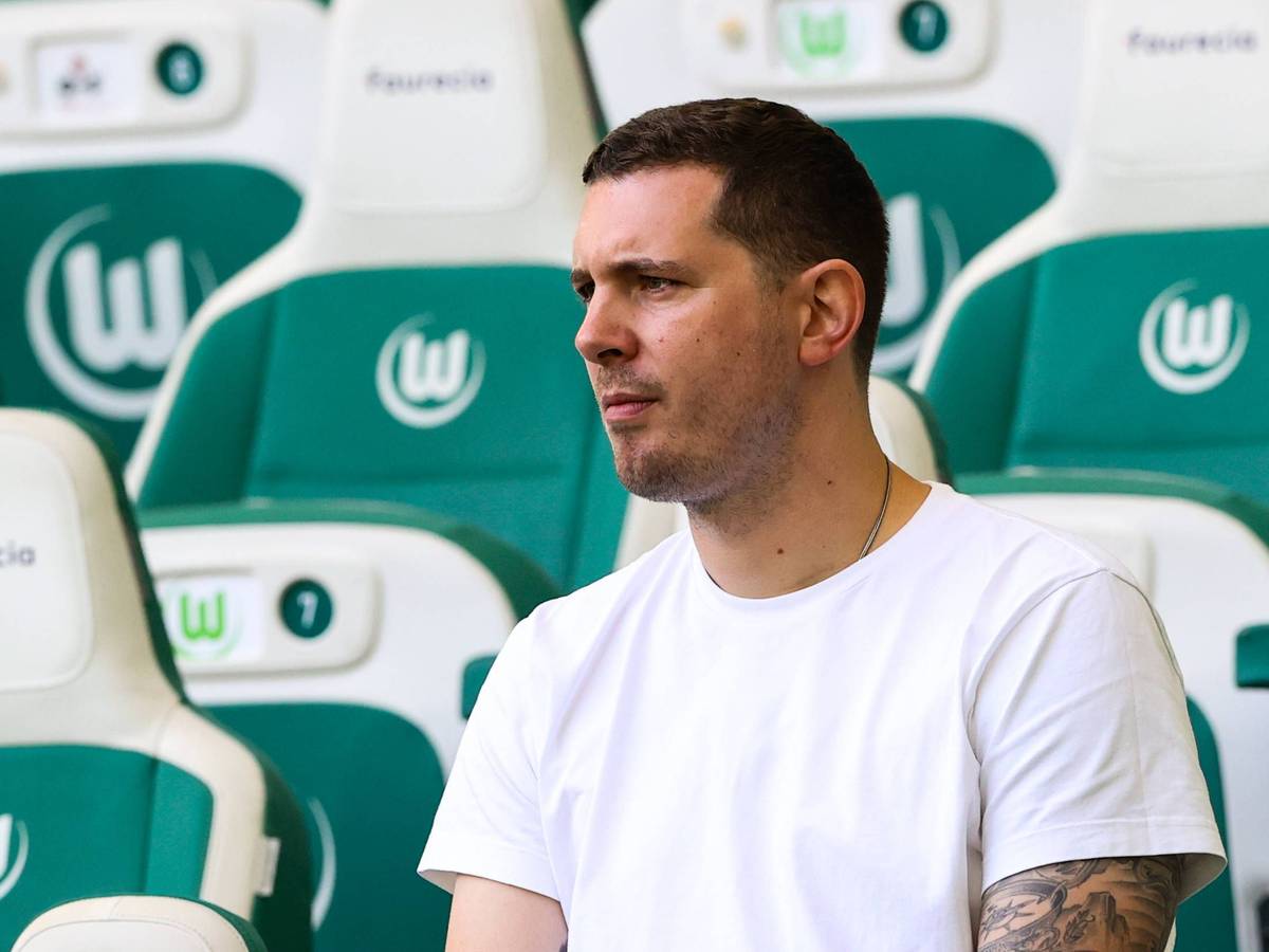 Nils Schmadtke sitzt beim Bundesliga-Spiel des VfL Wolfsburg gegen den FC Bayern München auf der Tribüne und beobachtet das Geschehen auf dem Rasen.