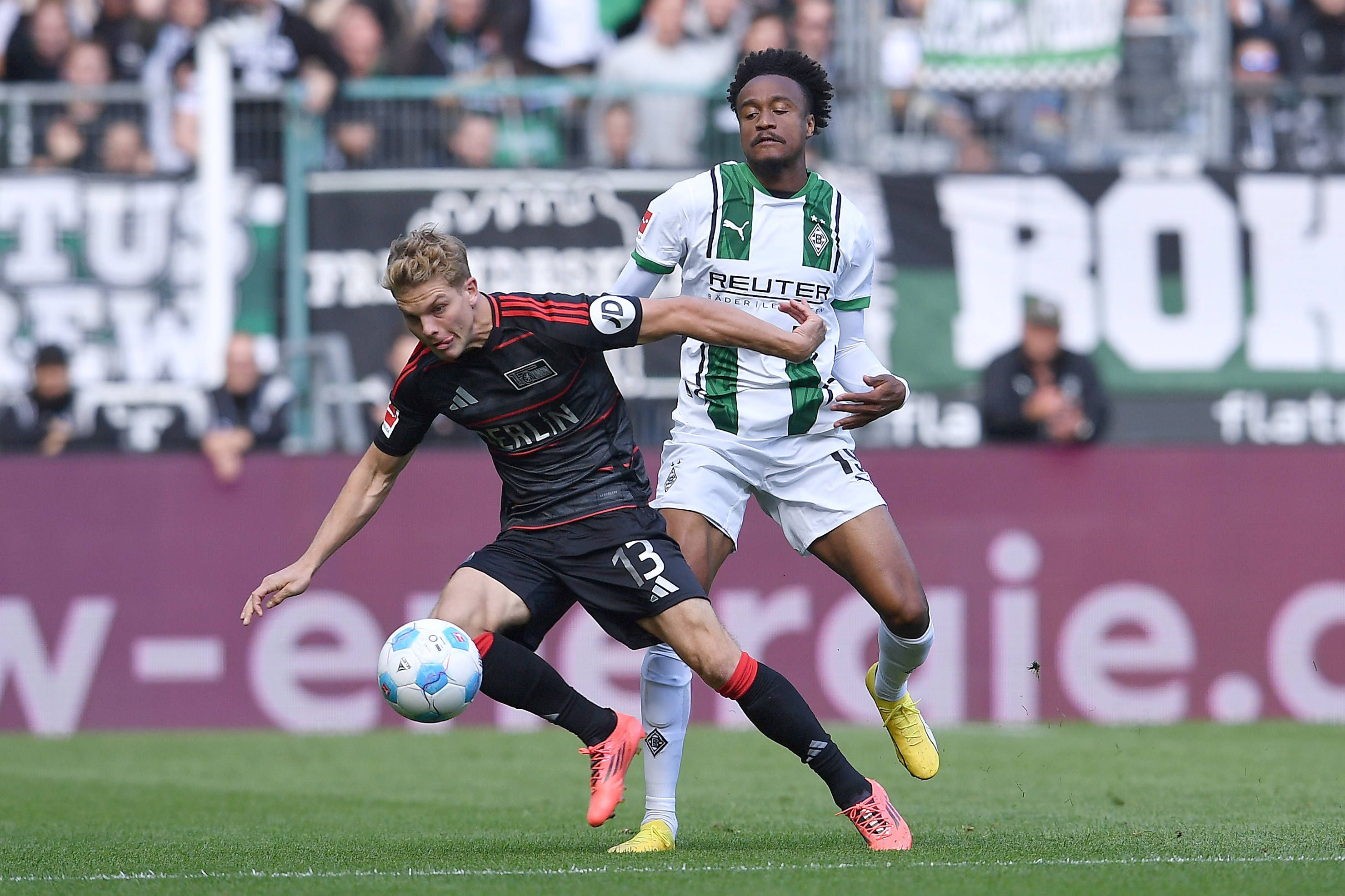 Borussia Mönchengladbachs Nathan Ngoumou und Union Berlins Andras Schäfer kämpfen um den Ball.
