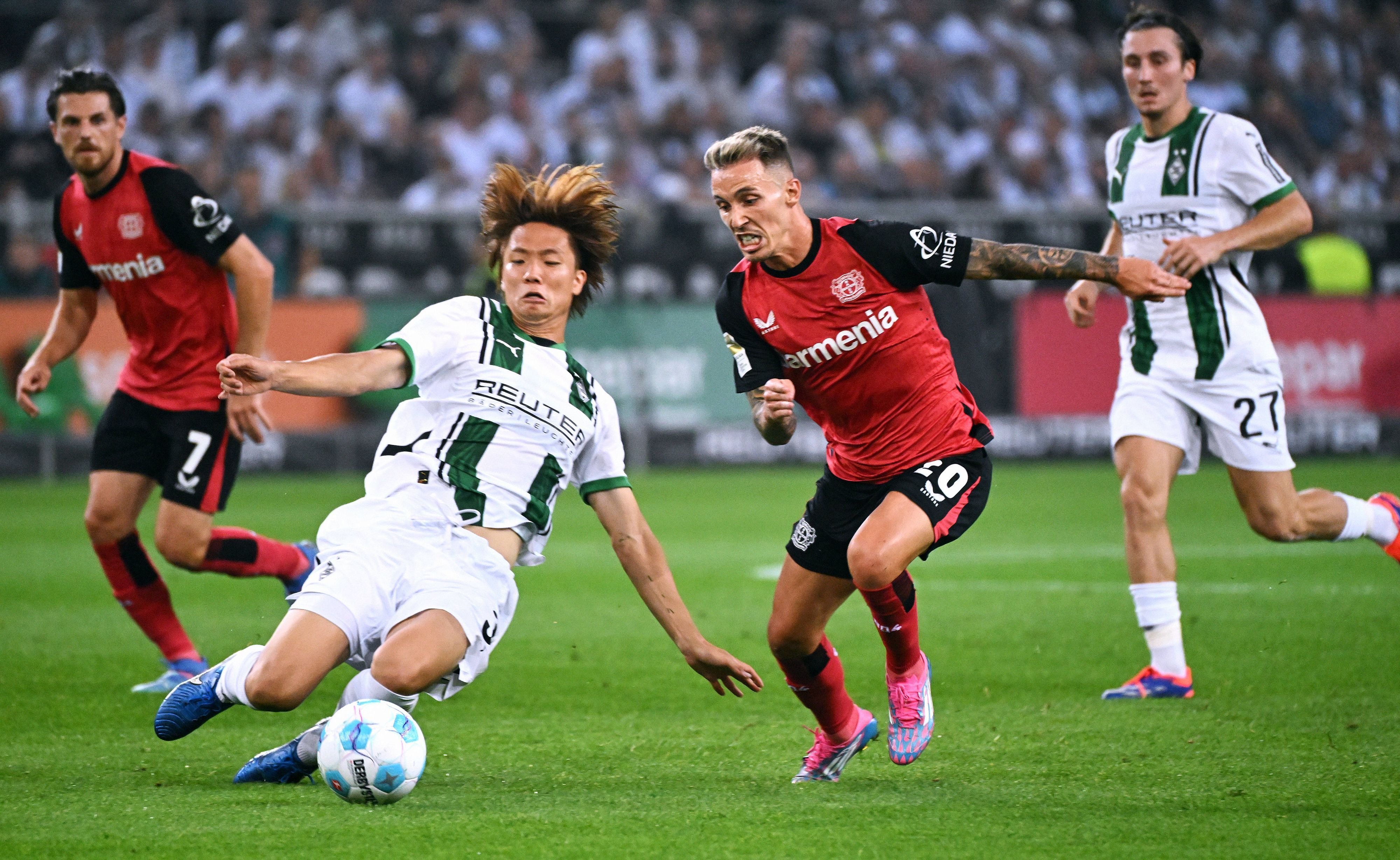 Borussia Mönchengladbachs Ko Itakura grätscht gegen Bayer Leverkusens Alejandro Grimaldo.