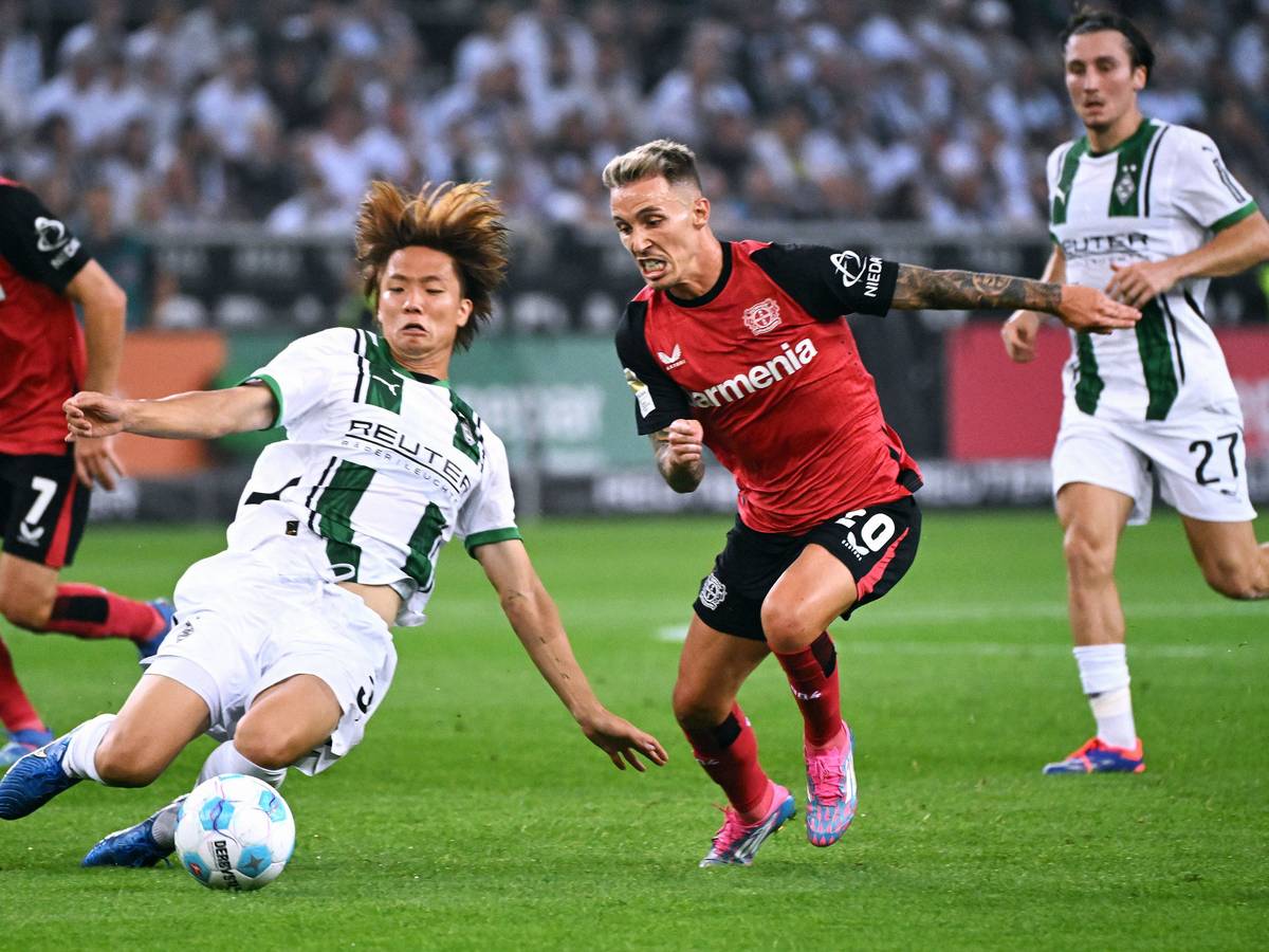 Borussia Mönchengladbachs Ko Itakura grätscht gegen Bayer Leverkusens Alejandro Grimaldo.