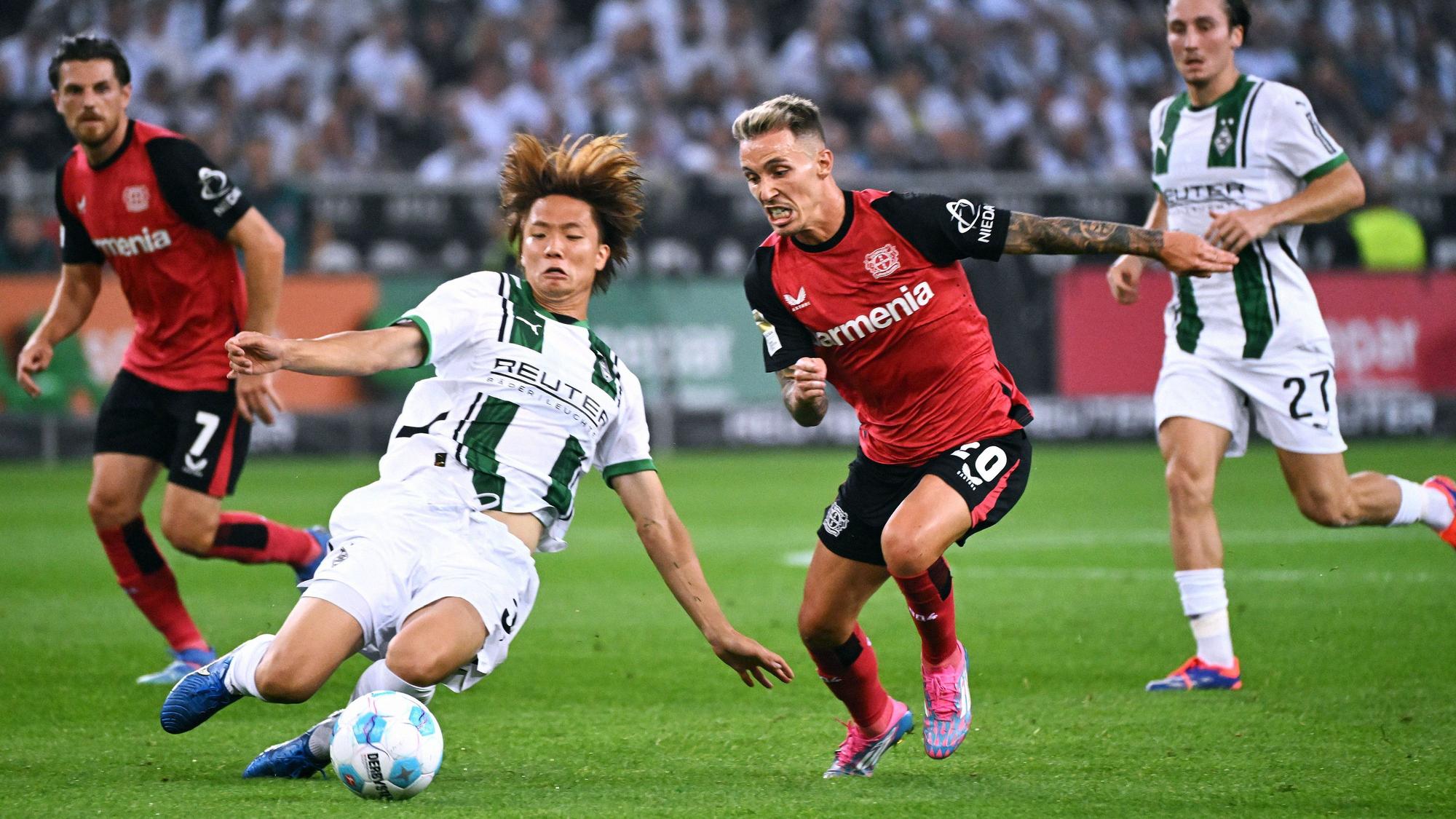 Borussia Mönchengladbachs Ko Itakura grätscht gegen Bayer Leverkusens Alejandro Grimaldo.