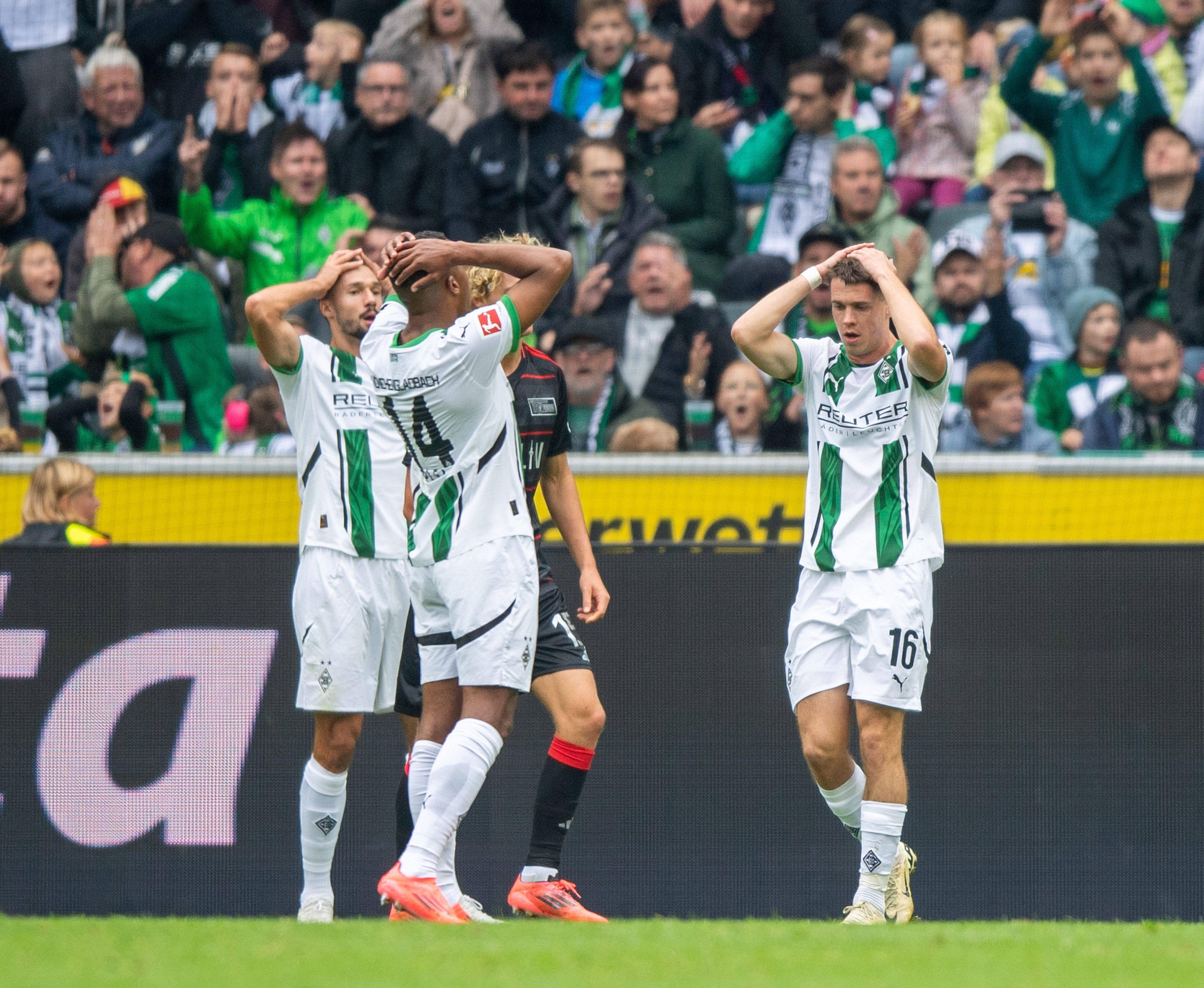 Spieler von Borussia Mönchengladbach sind frustriert und schlagen die Hände über den Kopf.