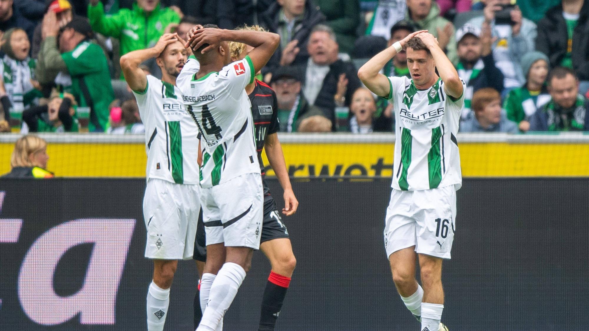 Spieler von Borussia Mönchengladbach sind frustriert und schlagen die Hände über den Kopf.