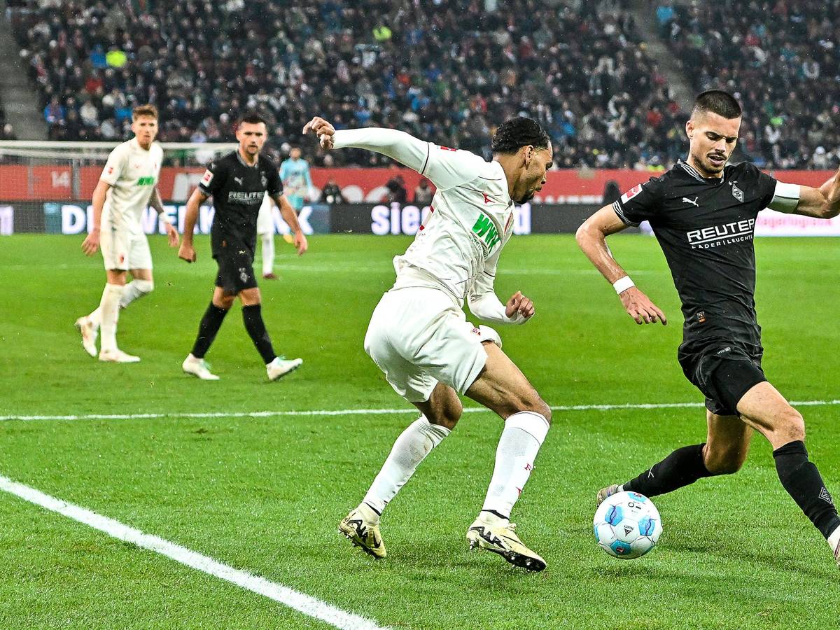 Augsburgs Alexis Claude-Maurice und Borussia Mönchengladbachs Julian Weigl kämpfen um den Ball.