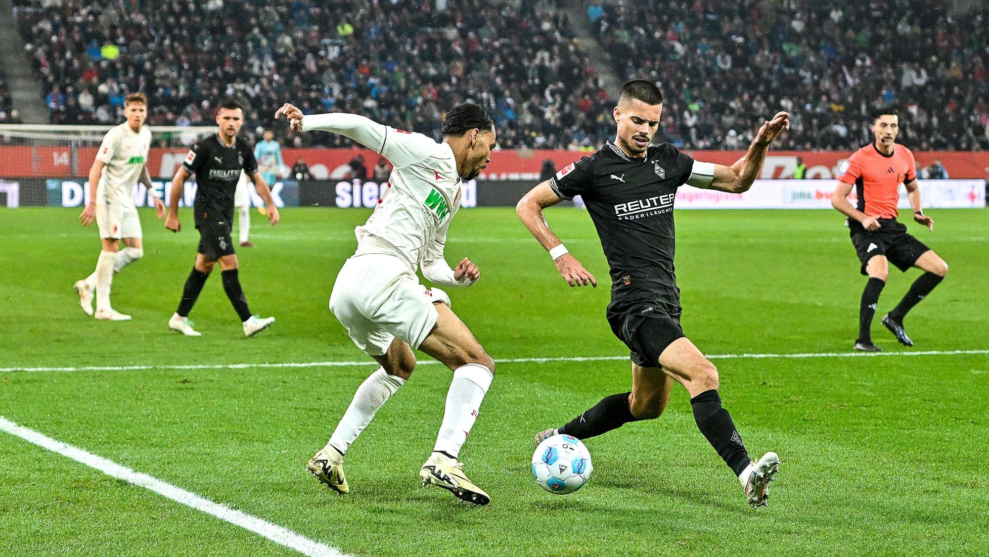 Augsburgs Alexis Claude-Maurice und Borussia Mönchengladbachs Julian Weigl kämpfen um den Ball.