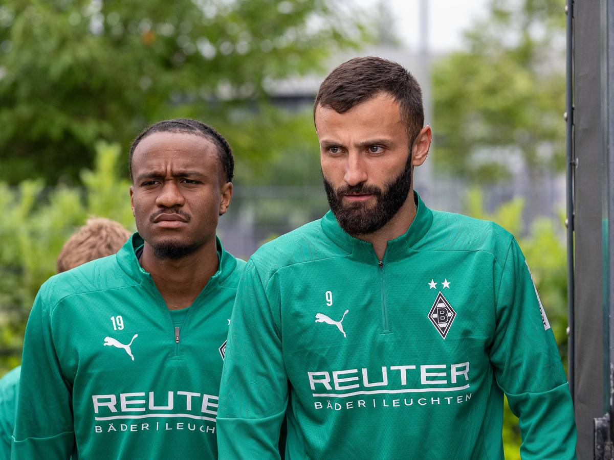 Die Gladbach-Profis Franck Honorat und nathan Ngoumou laufen hintereinander auf den Trainingsplatz.