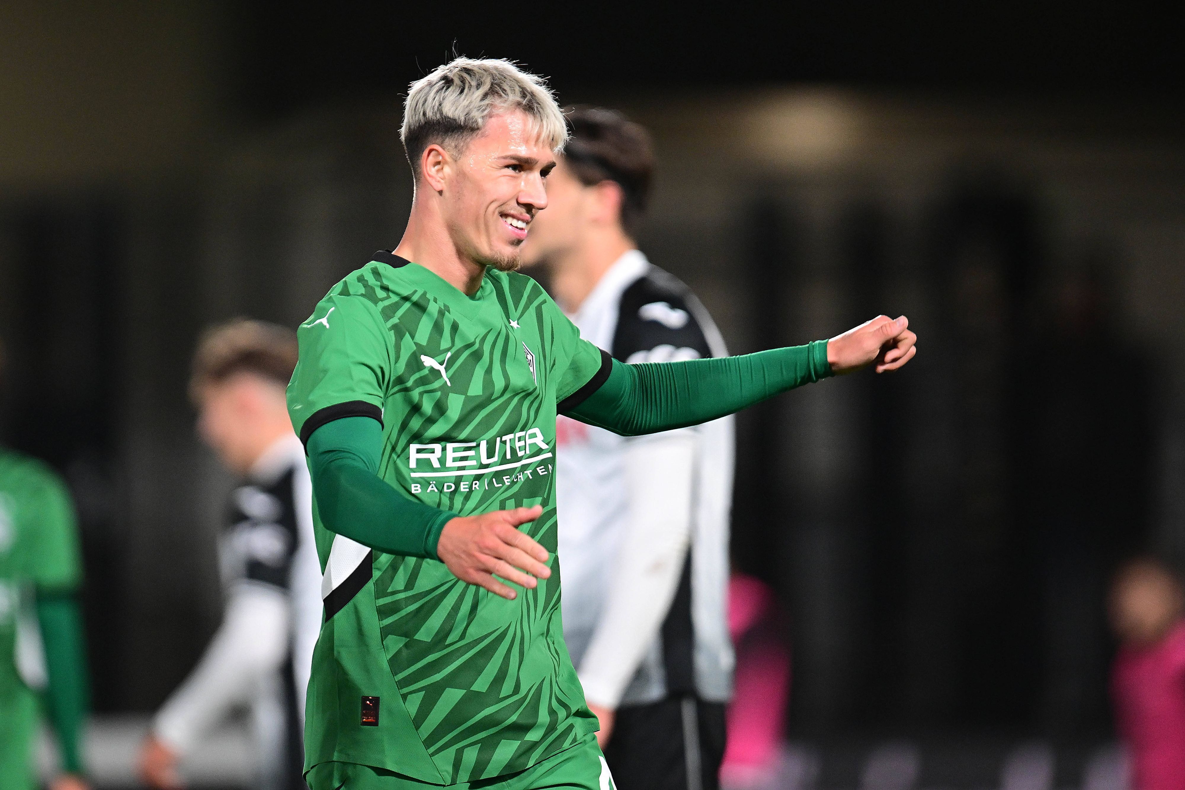 Noah Pesch lächelt im Gladbach-Trikot.