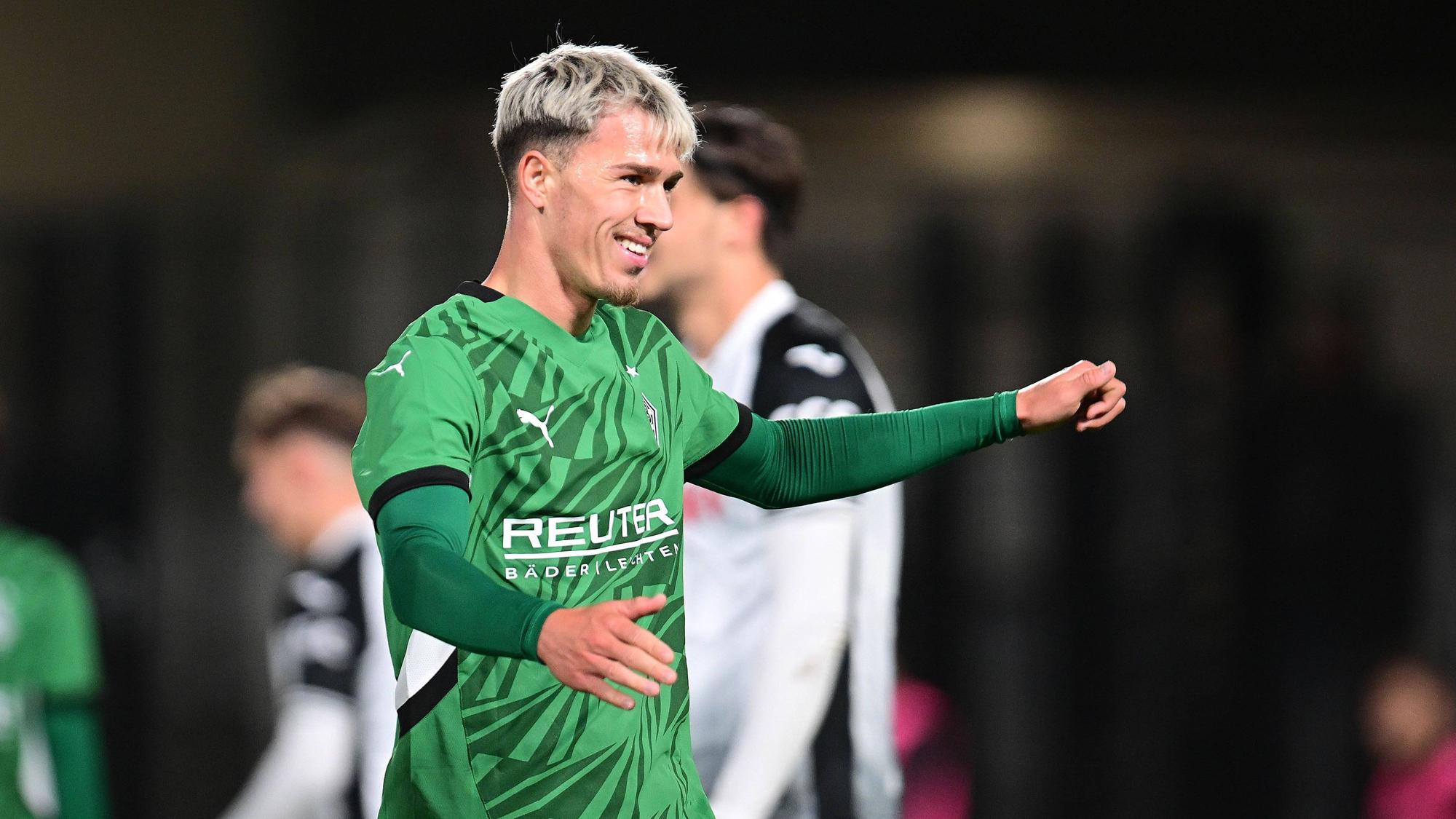 Noah Pesch lächelt im Gladbach-Trikot.