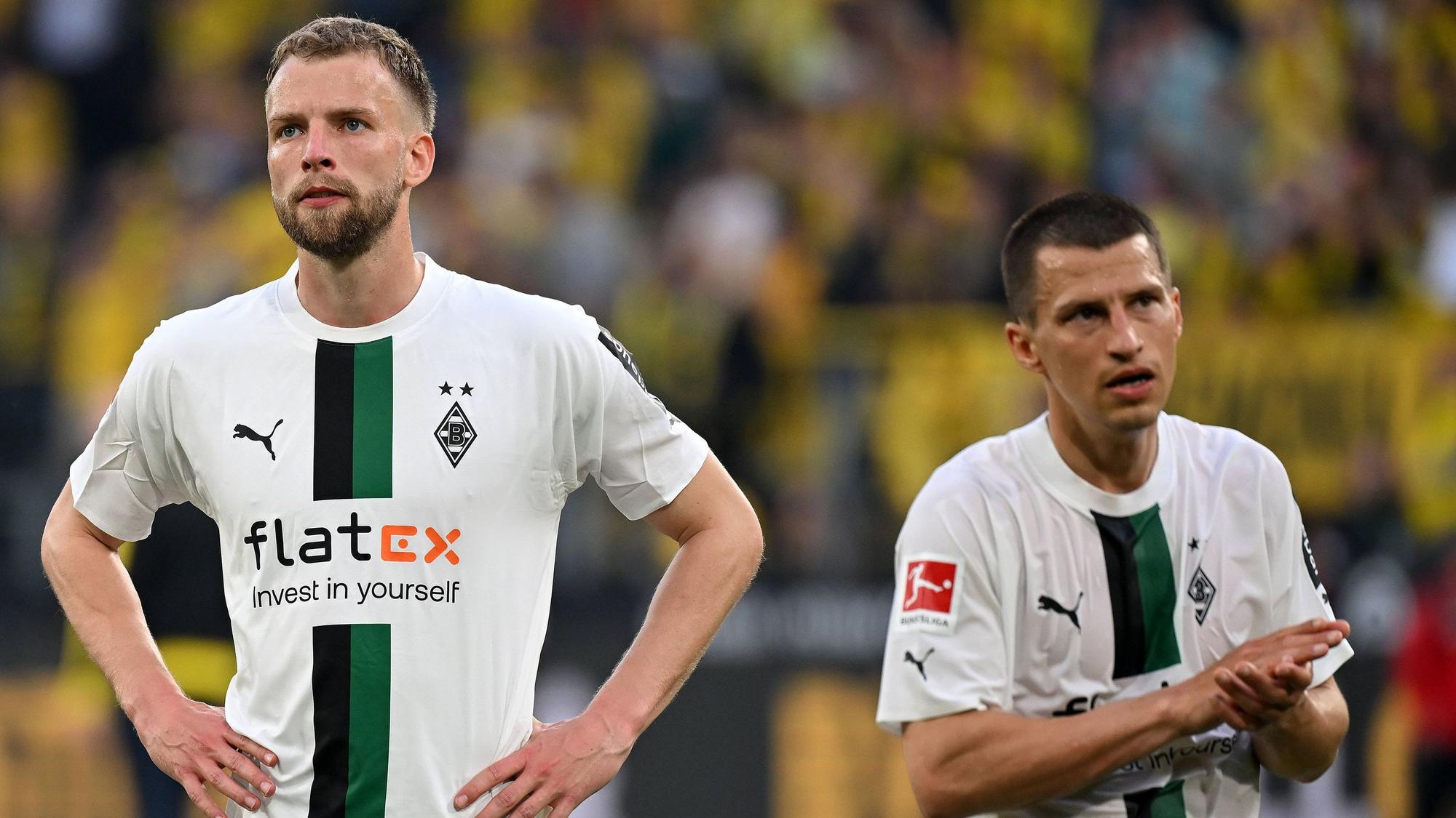 Die Gladbach-Profis Marvin Friedrich und Stefan Lainer stehen nach dem Spiel in Dortmund enttäuscht nebeneinander auf dem Platz.