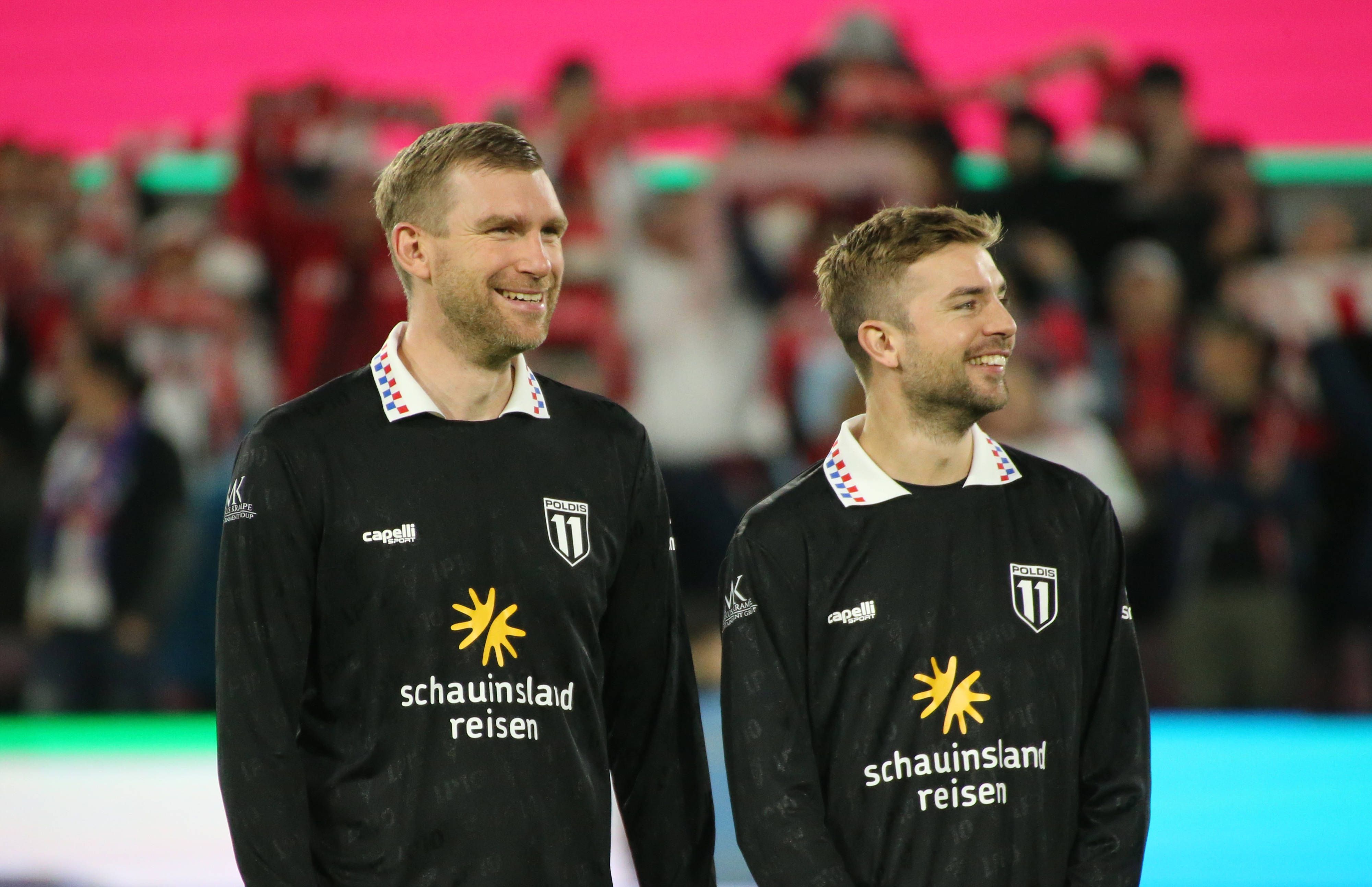 Per Mertesacker und Christoph Kramer stehen bei Lukas Podolskis Abschiedsspiel lachend nebeneinander auf dem Platz.