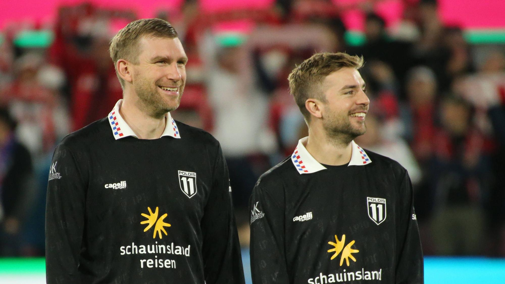 Per Mertesacker und Christoph Kramer stehen bei Lukas Podolskis Abschiedsspiel lachend nebeneinander auf dem Platz.
