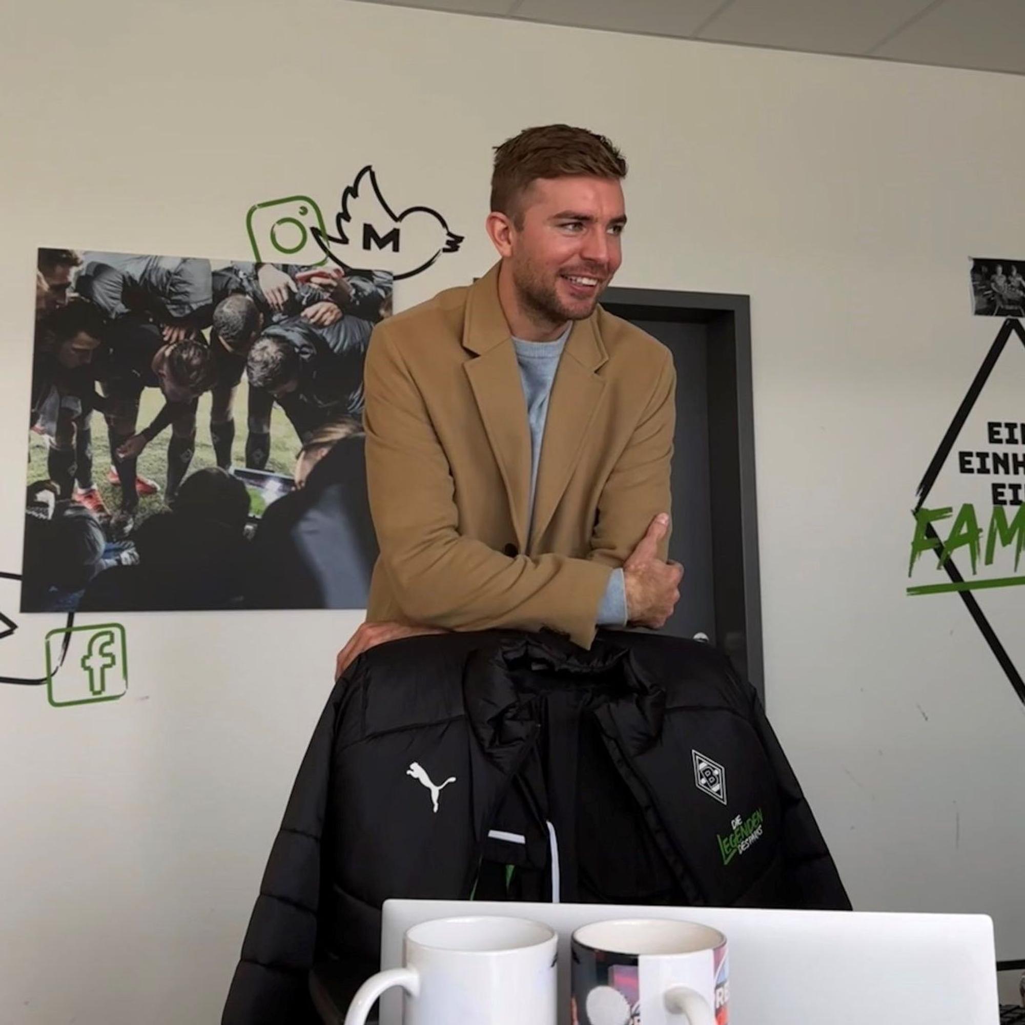 Christoph Kramer lehnt in einem Büro des Borussia-Parks auf einer Stuhl-Lehne.
