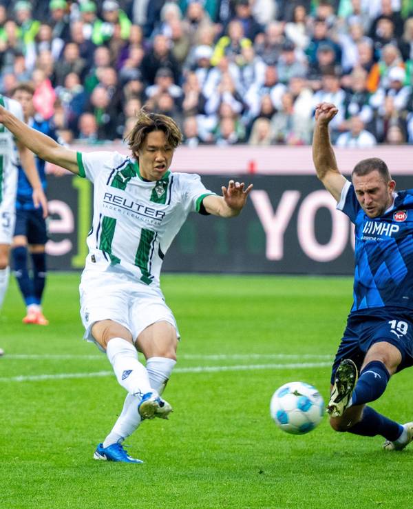 Borussia Mönchengladbachs Ko Itakura zieht ab, Heidenheims Jonas Föhrenbach versucht zu blocken.