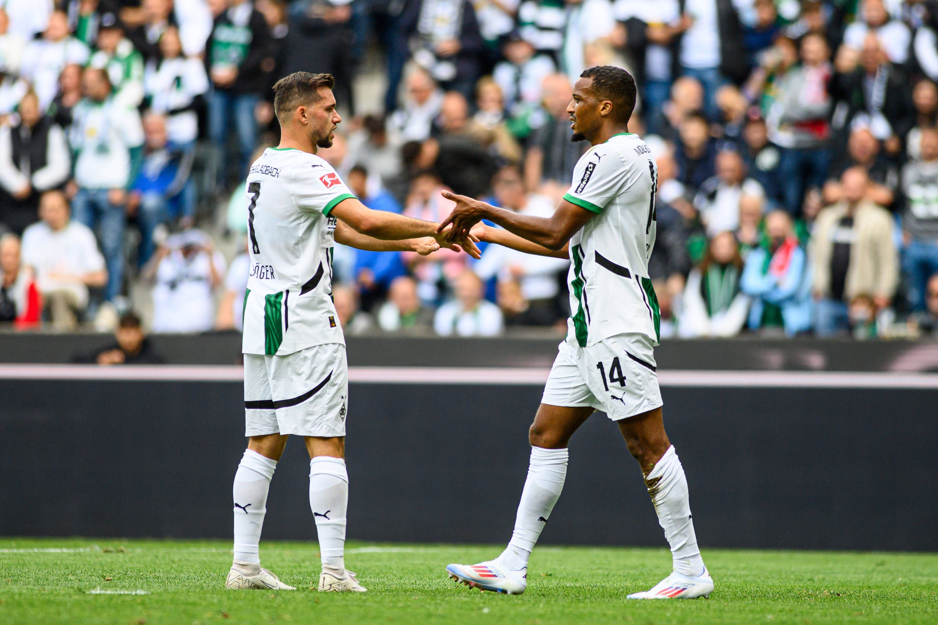Kevin Stöger und Alassane Plea klatschen sich auf dem Spielfeld ab.