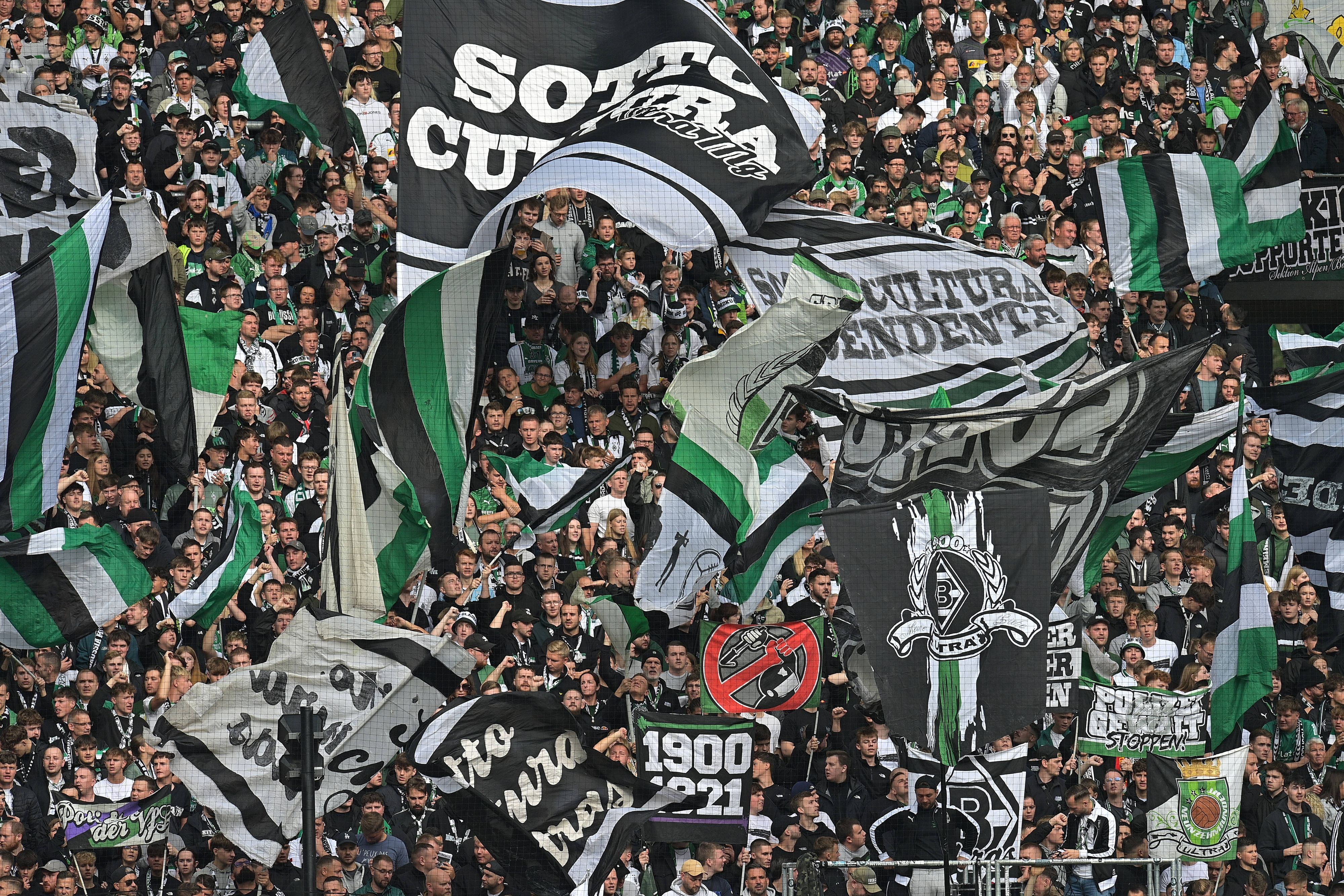 Fans von Borussia Mönchengladbach schwenken beim Bundesliga-Heimspiel gegen den 1. FC Heidenheim in der Nordkurve ihre Fahnen.