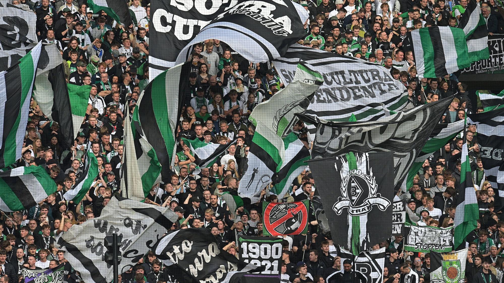 Fans von Borussia Mönchengladbach schwenken beim Bundesliga-Heimspiel gegen den 1. FC Heidenheim in der Nordkurve ihre Fahnen.
