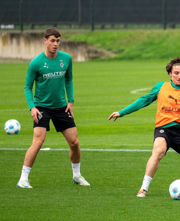 Die Gladbach-Profis Rocco Reitz und Ko Itakura kämpfen im Training um den Ball, links daneben beobachtet Philipp Sander die Szene.