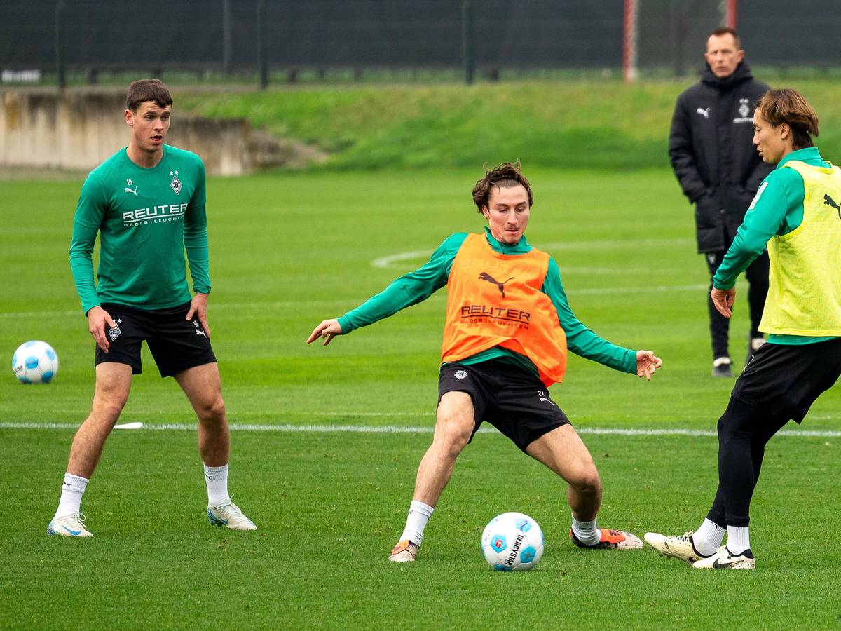 Die Gladbach-Profis Rocco Reitz und Ko Itakura kämpfen im Training um den Ball, links daneben beobachtet Philipp Sander die Szene.