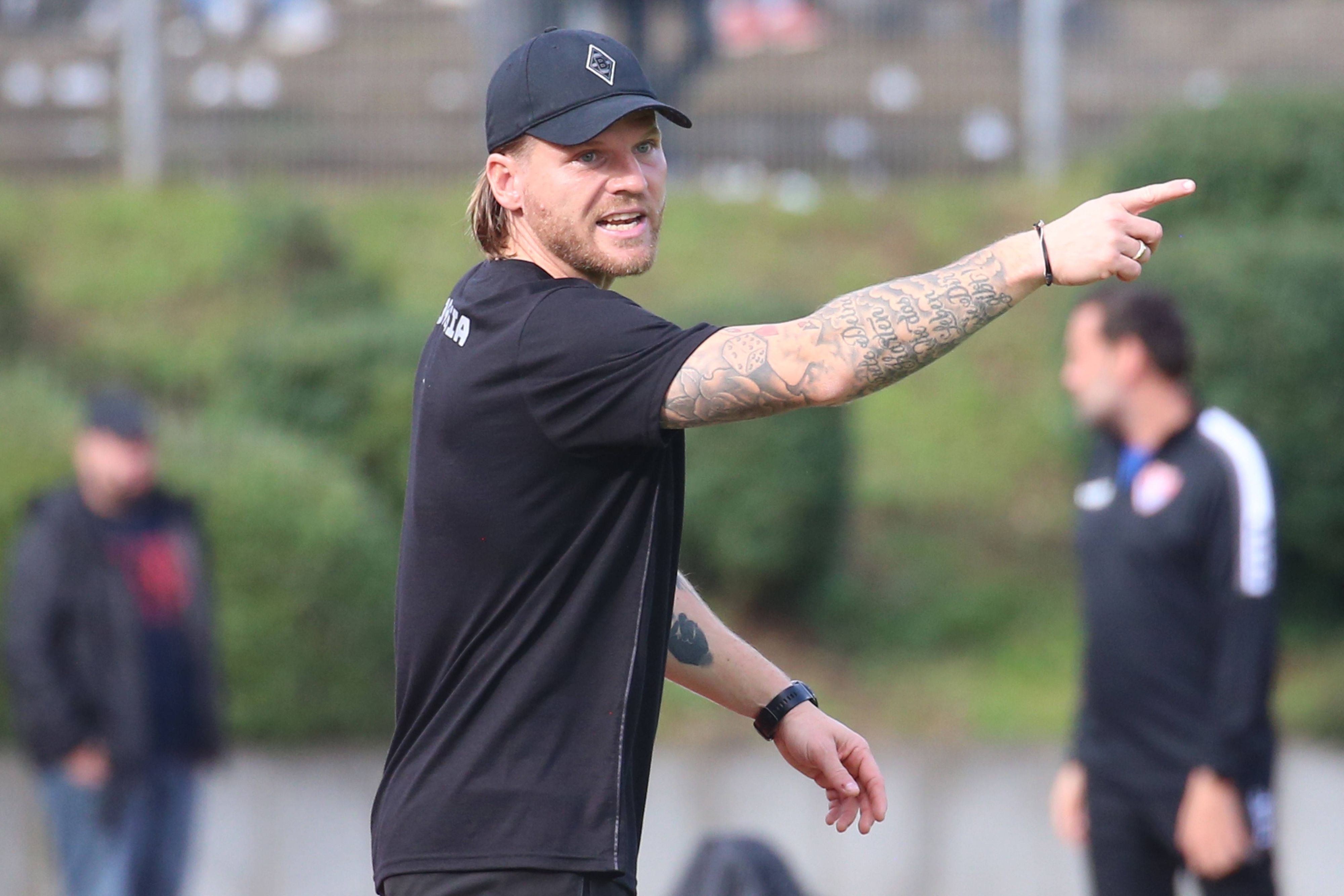 Eugen Polanski mit Gladbach-Cap am Spielfeldrand.