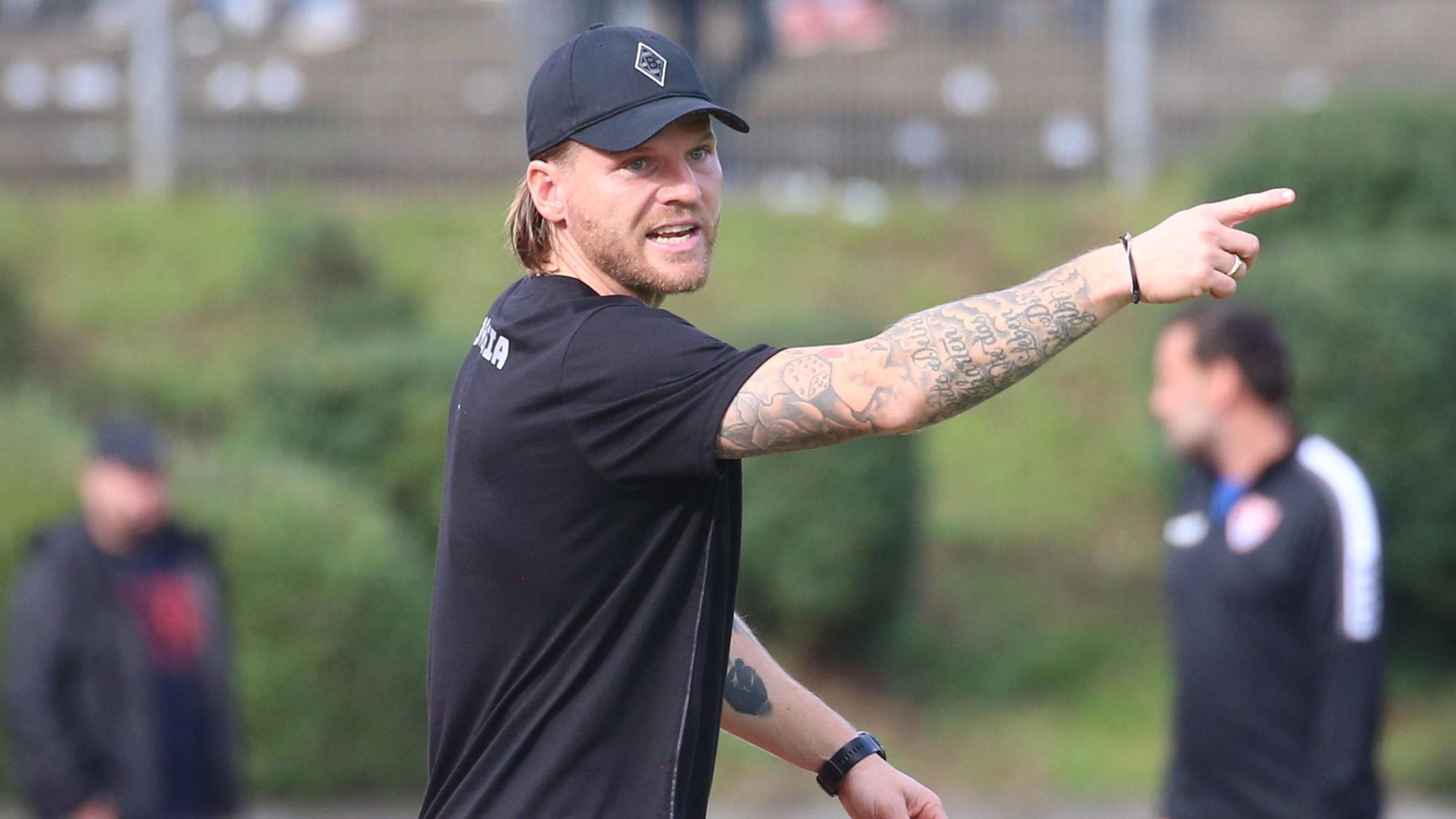 Eugen Polanski mit Gladbach-Cap am Spielfeldrand.