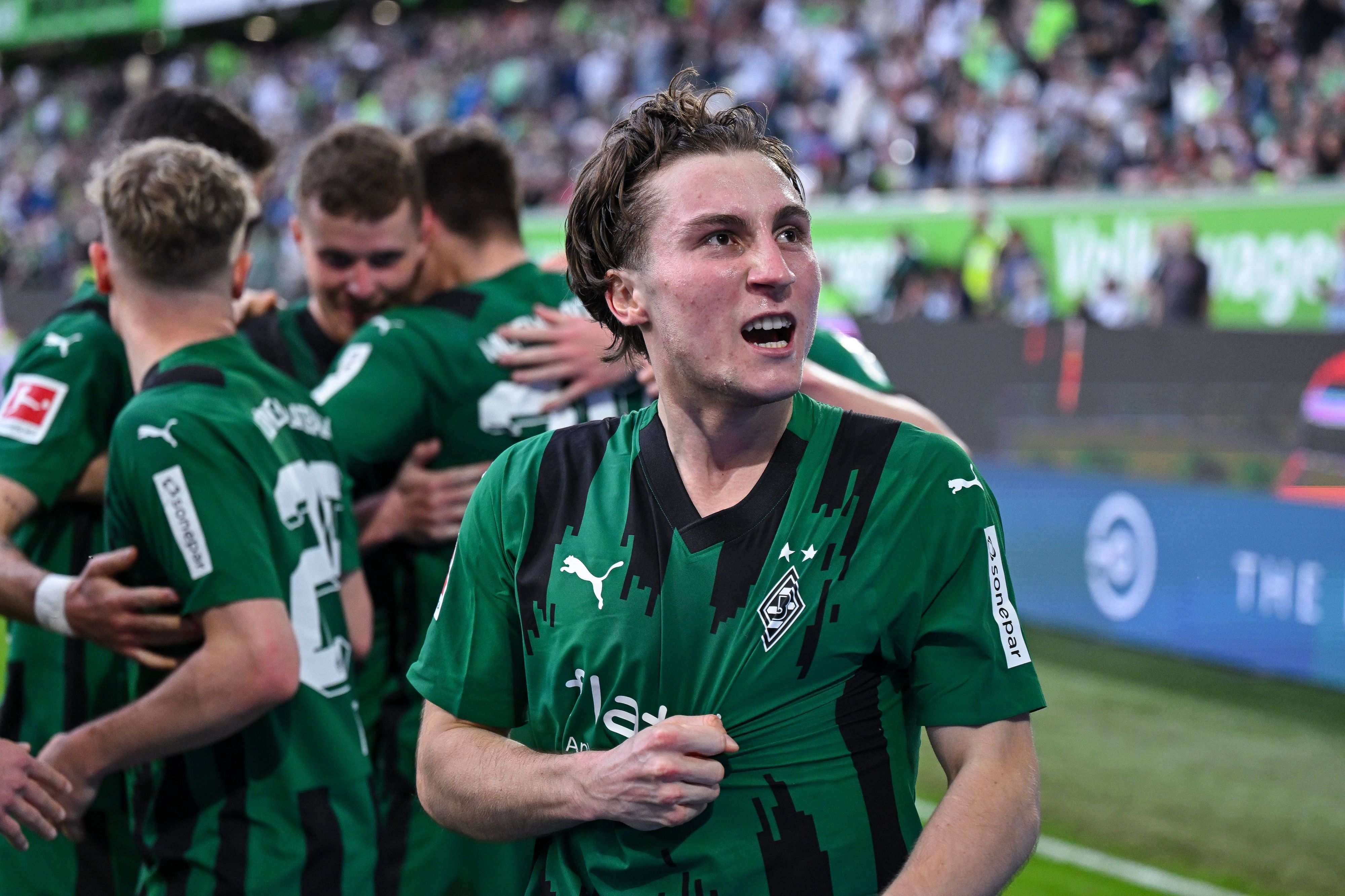 Rocco Reitz greift sich ins Trikot und schaut jubelnd zu den Fans hoch.